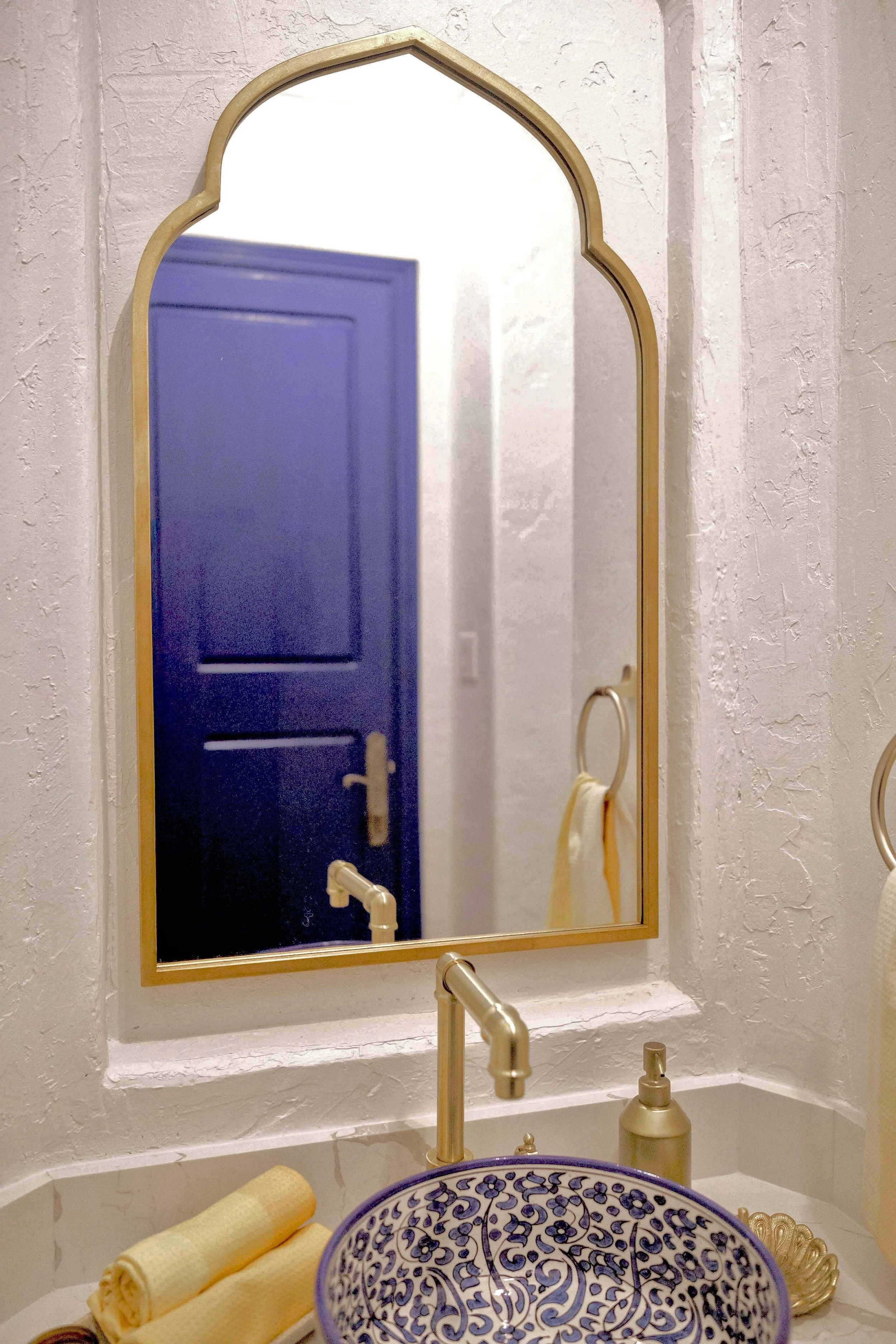 A mirror with a quintessentially Moroccan-shaped edge and a slim frame greets you as you walk in.