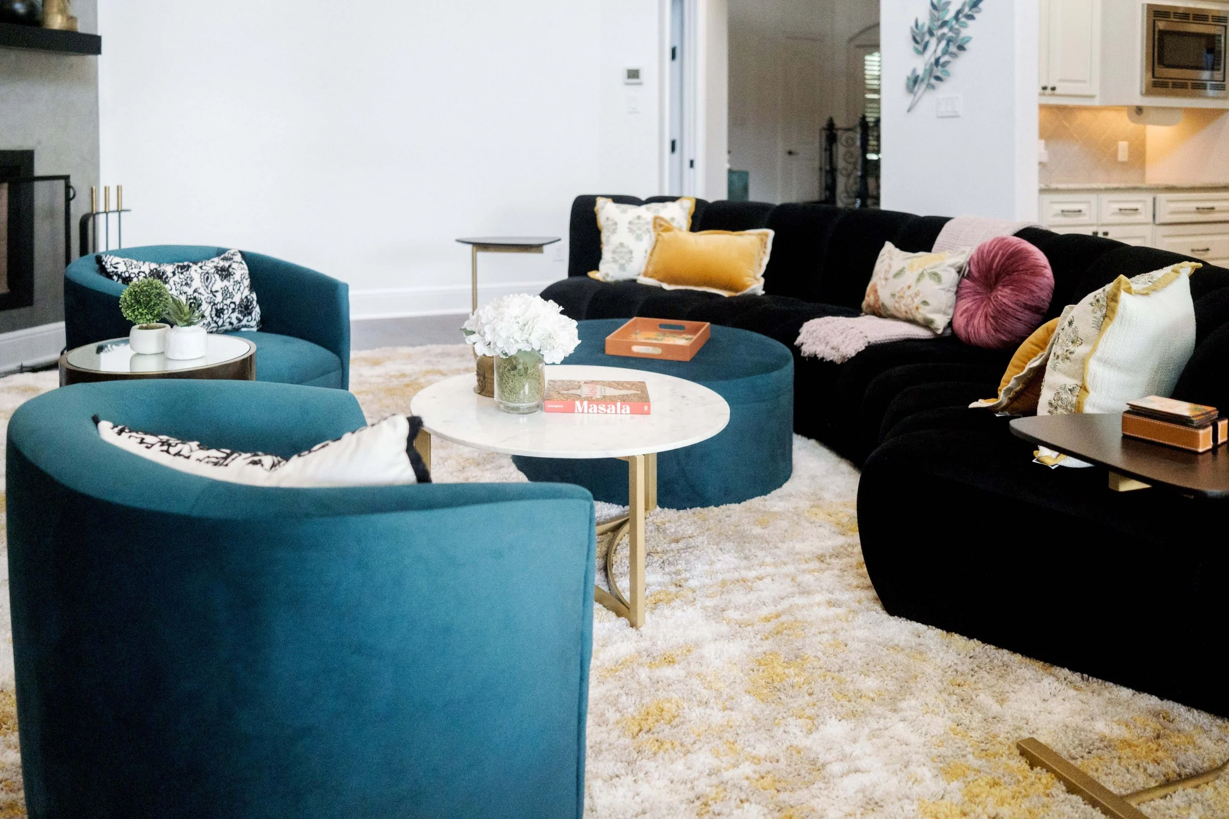 A marble coffee table and nested velvet ottoman provides both plenty of room for resting things on, as well as a place to put up your feet at the end of the day.