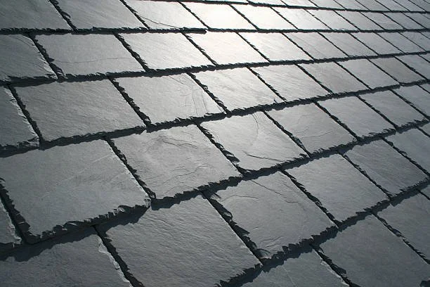 Gray slate roofing material arranged in a traditional overlapping pattern for a distinctive architectural roof surface.
