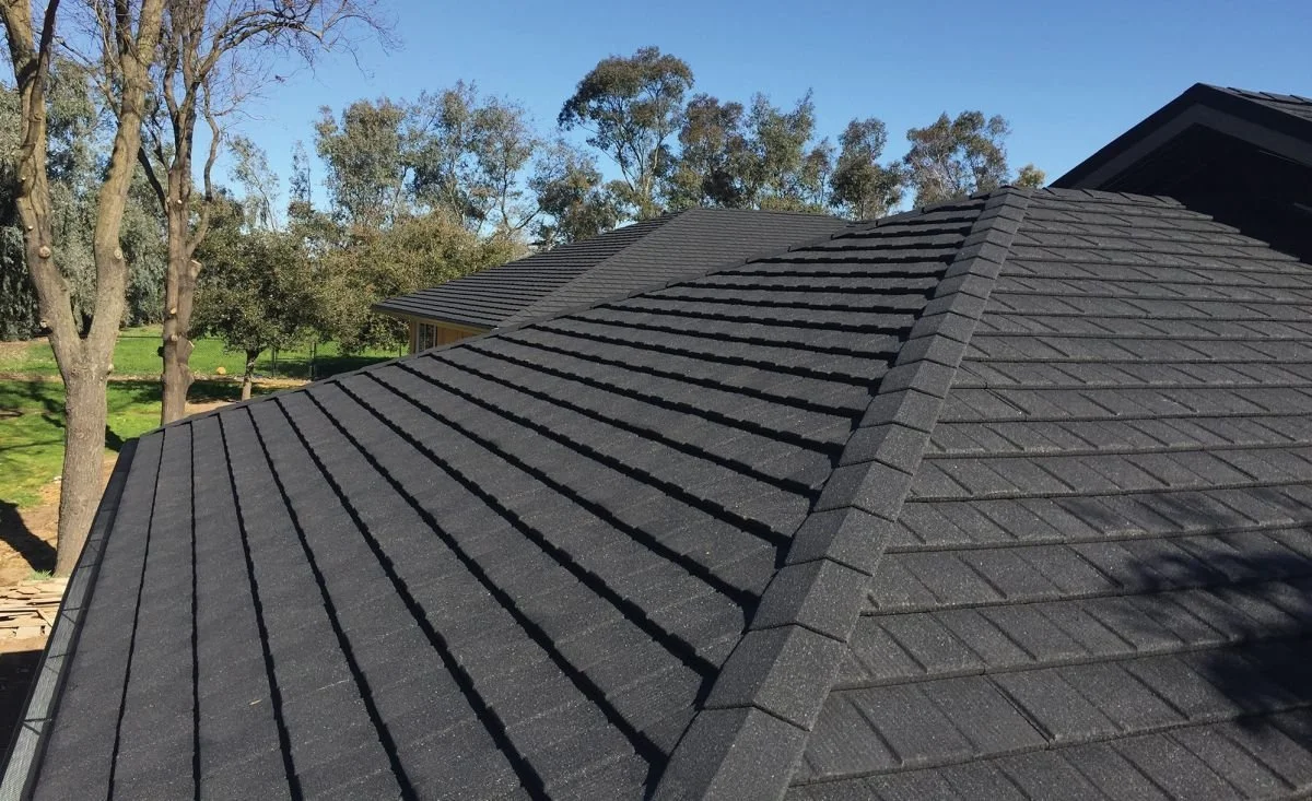 Exterior view of a residential roof featuring dark stone-coated steel roof panels.