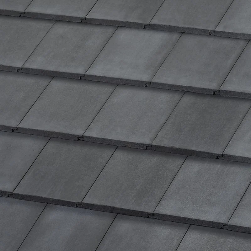 Close-up texture of dark gray interlocking concrete roof tiles.