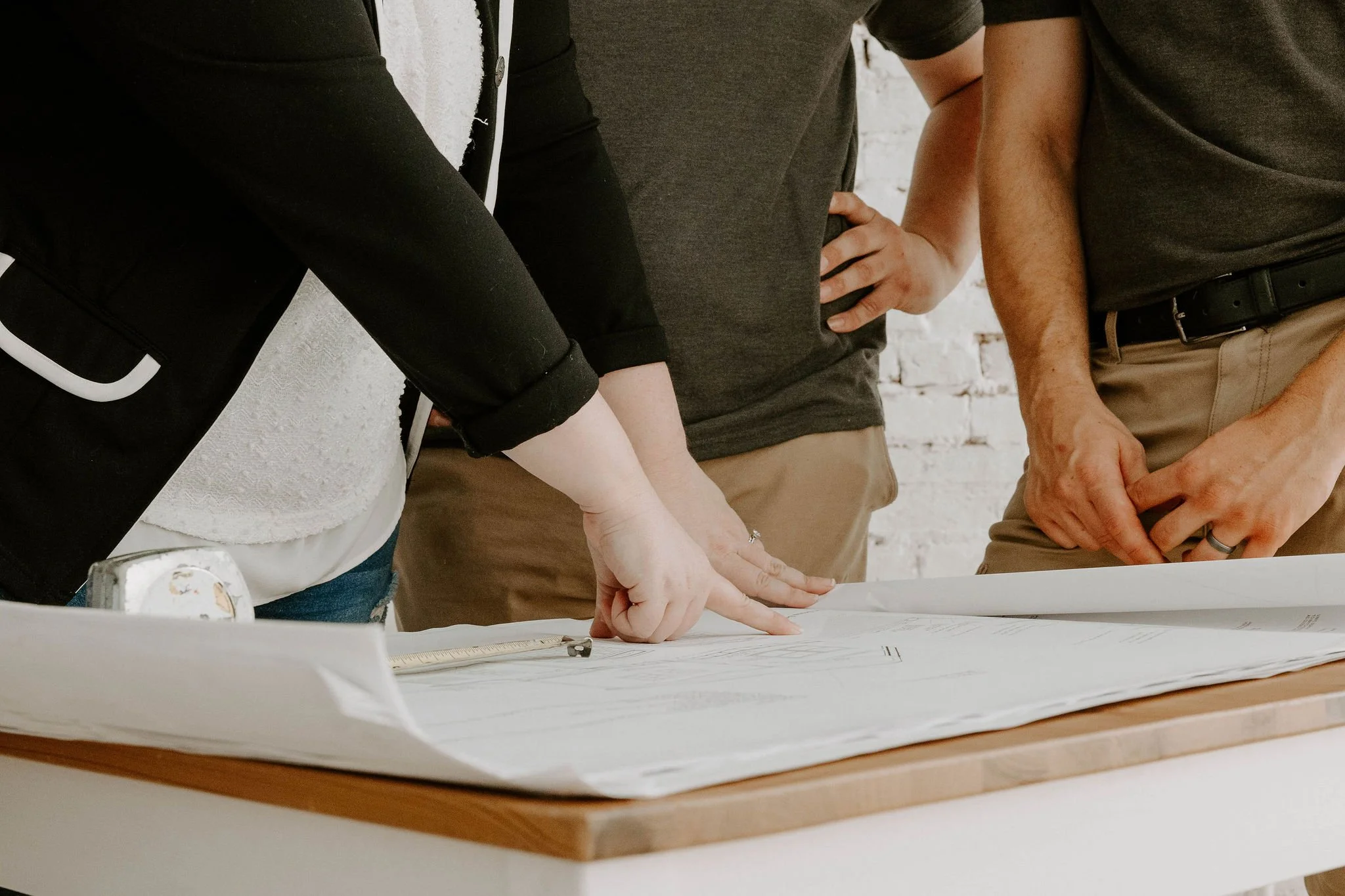 General contracting team reviewing architectural blueprints and project plans during a collaborative construction planning session.