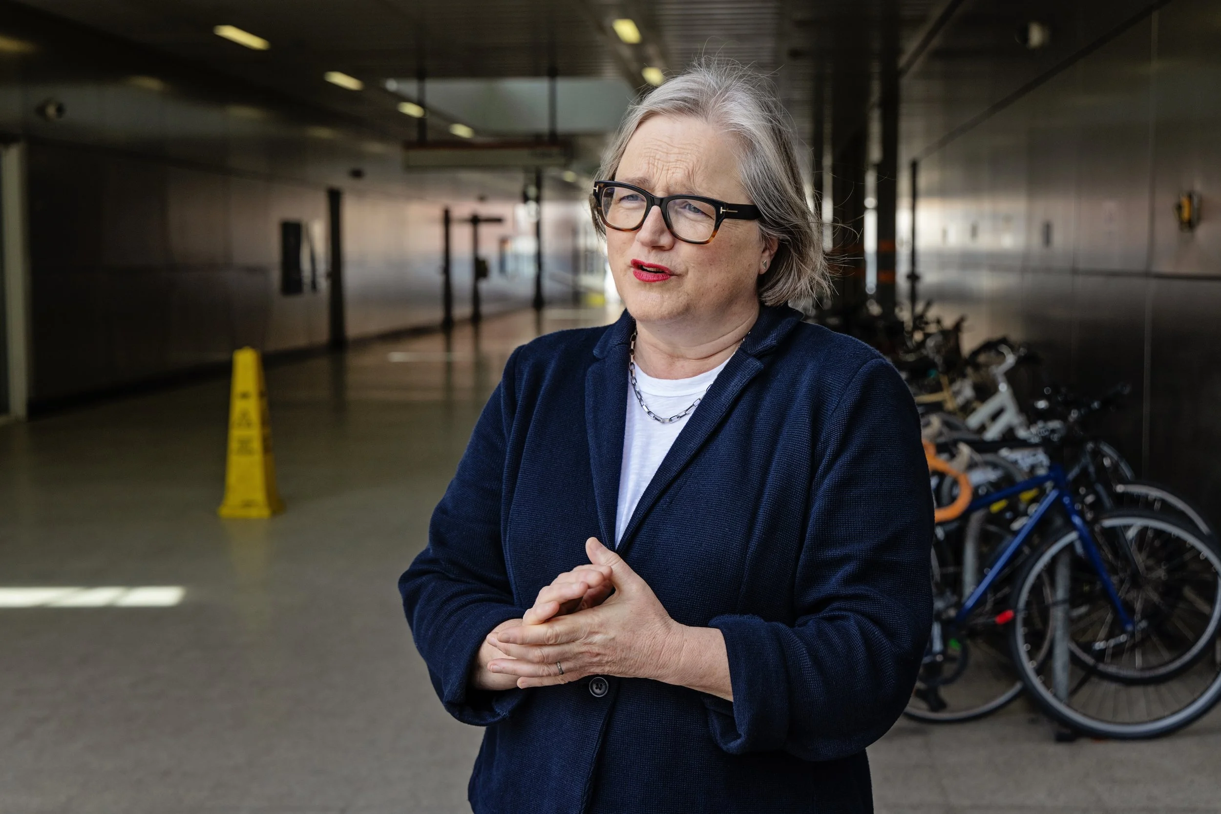 Caroline Russell standing in front of a station showing bicycles behind