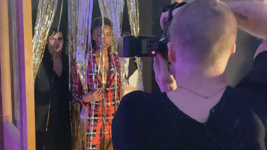 Photographer taking pictures of models behind gold streamers