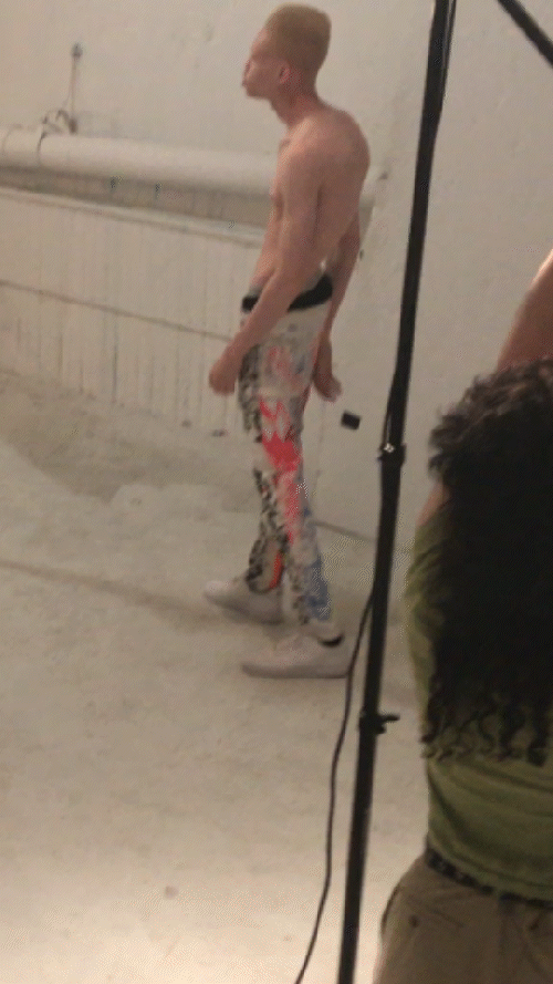 Person in colorful pants posing in a studio setting