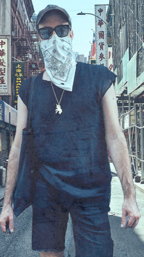 Person wearing a mask and sunglasses in an urban street
