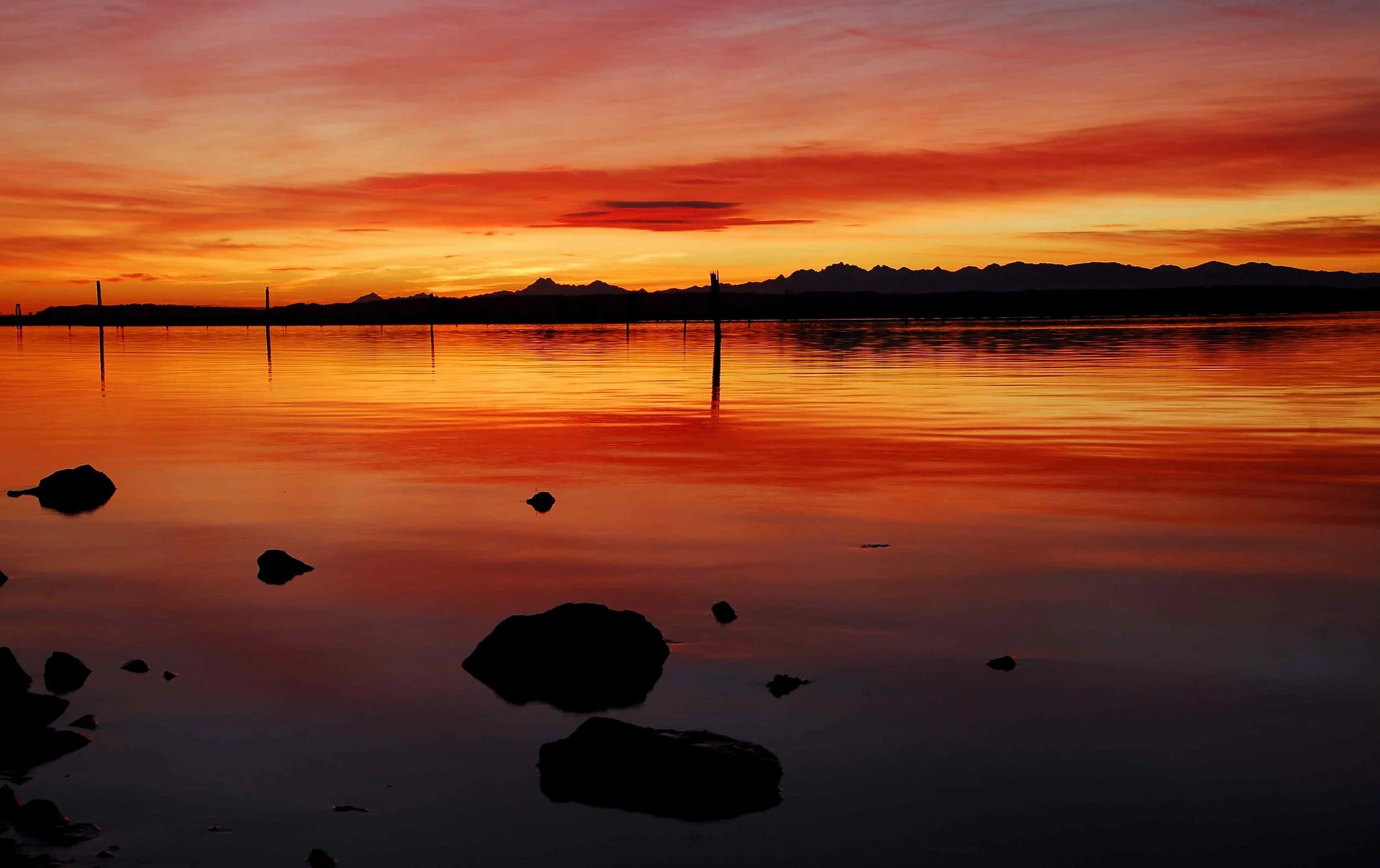 This is the most beautiful sunset I have ever witnessed and was taken on a cool fall day near Everett, WA. The scene contains the waters of Possession Sound near the Naval Station with the sun setting over the horizon and Olympic Mountain range which