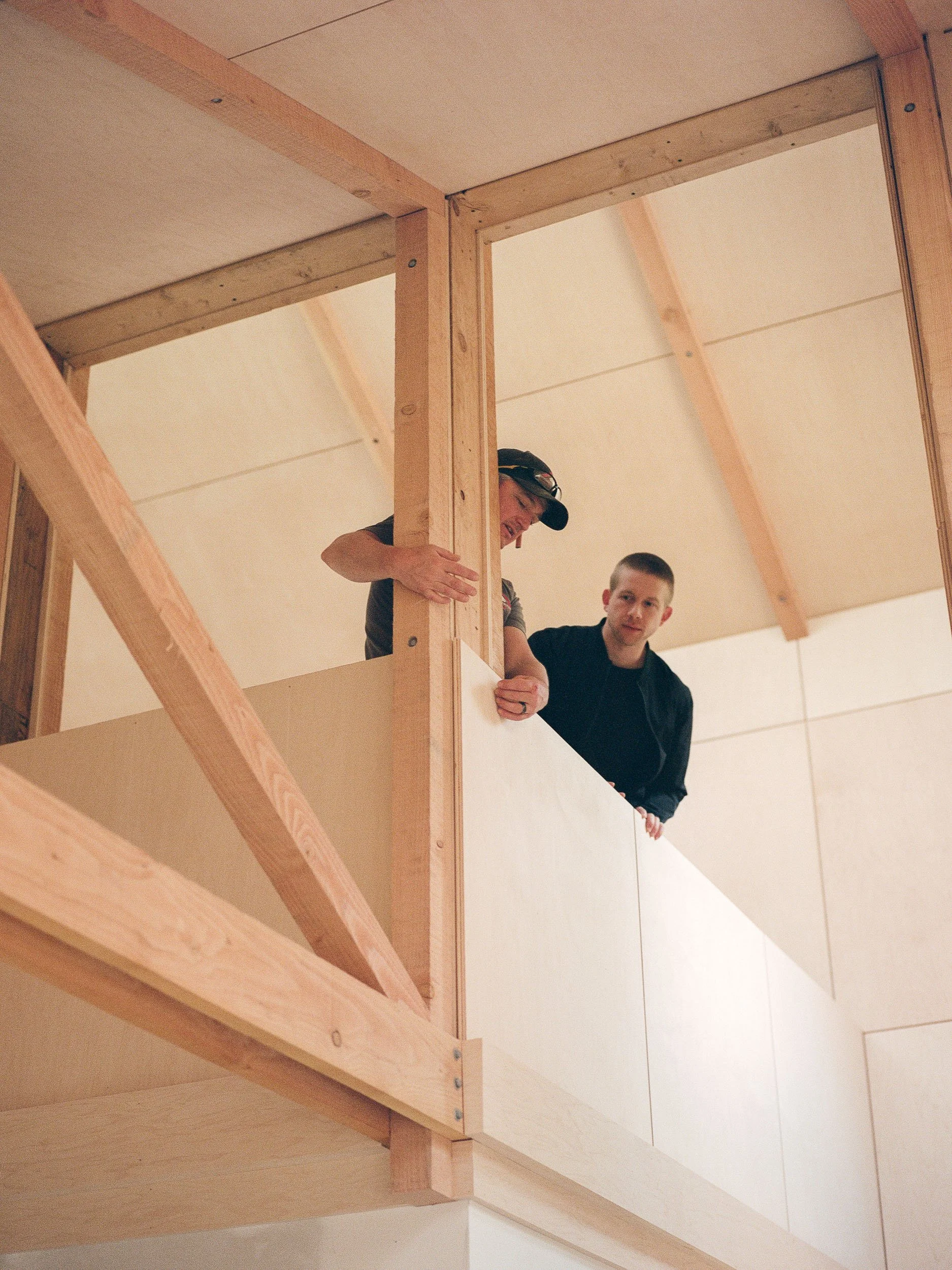 Architect with builder in nordic plywood cabin.