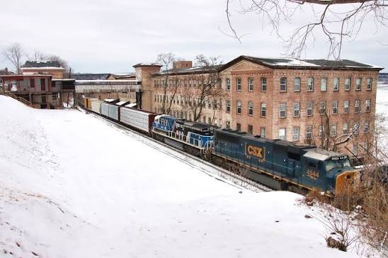 A train traveling through a snowy landscape next to boudoir-ny located in the the Hudson Valley Boudoir Studio building, 