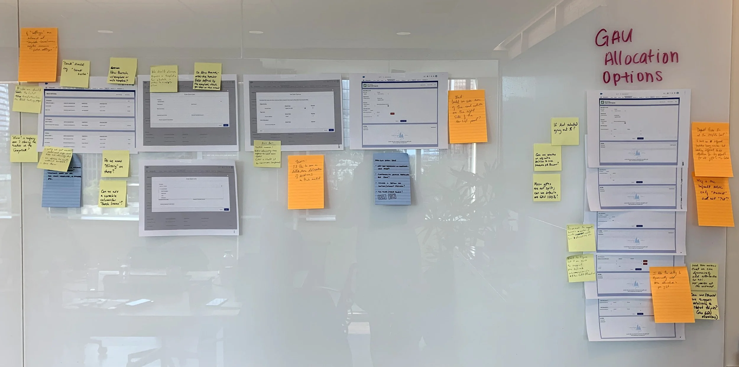 Whiteboard of designs with post-it notes containing feedback