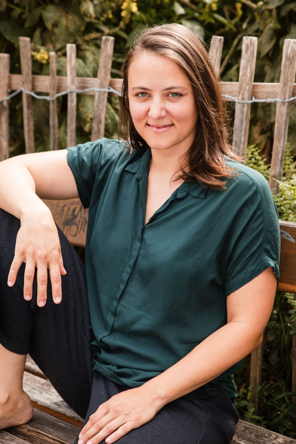 Körpertherapeutin Valentina Wieser, lächelnd auf einer Bank