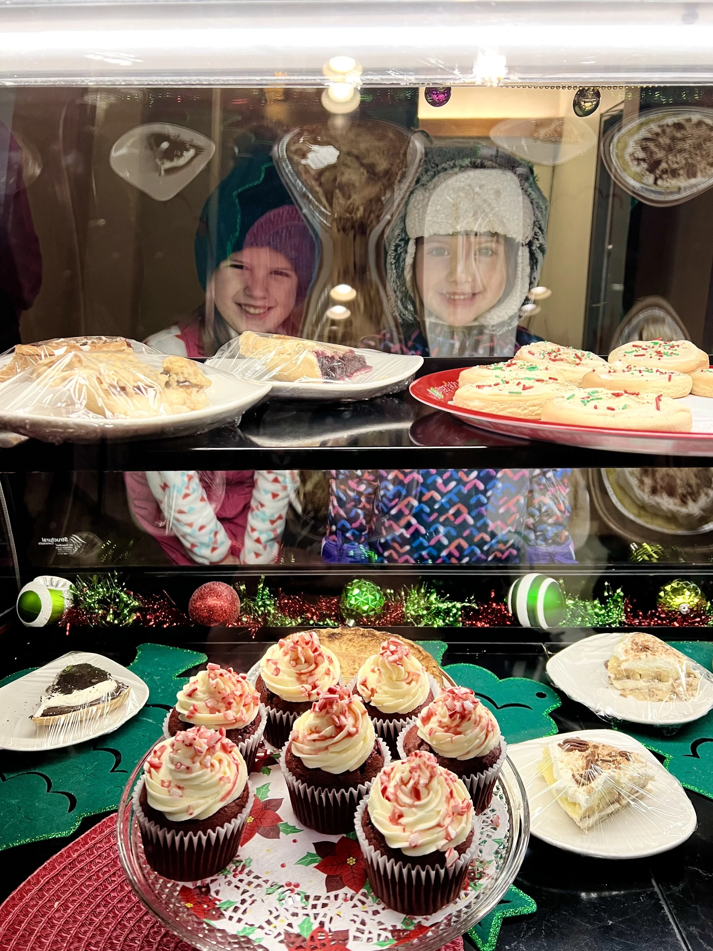 A photo of two smiling children peering through the pie case at the Sunset Cafe and Loose Wolf Saloon.