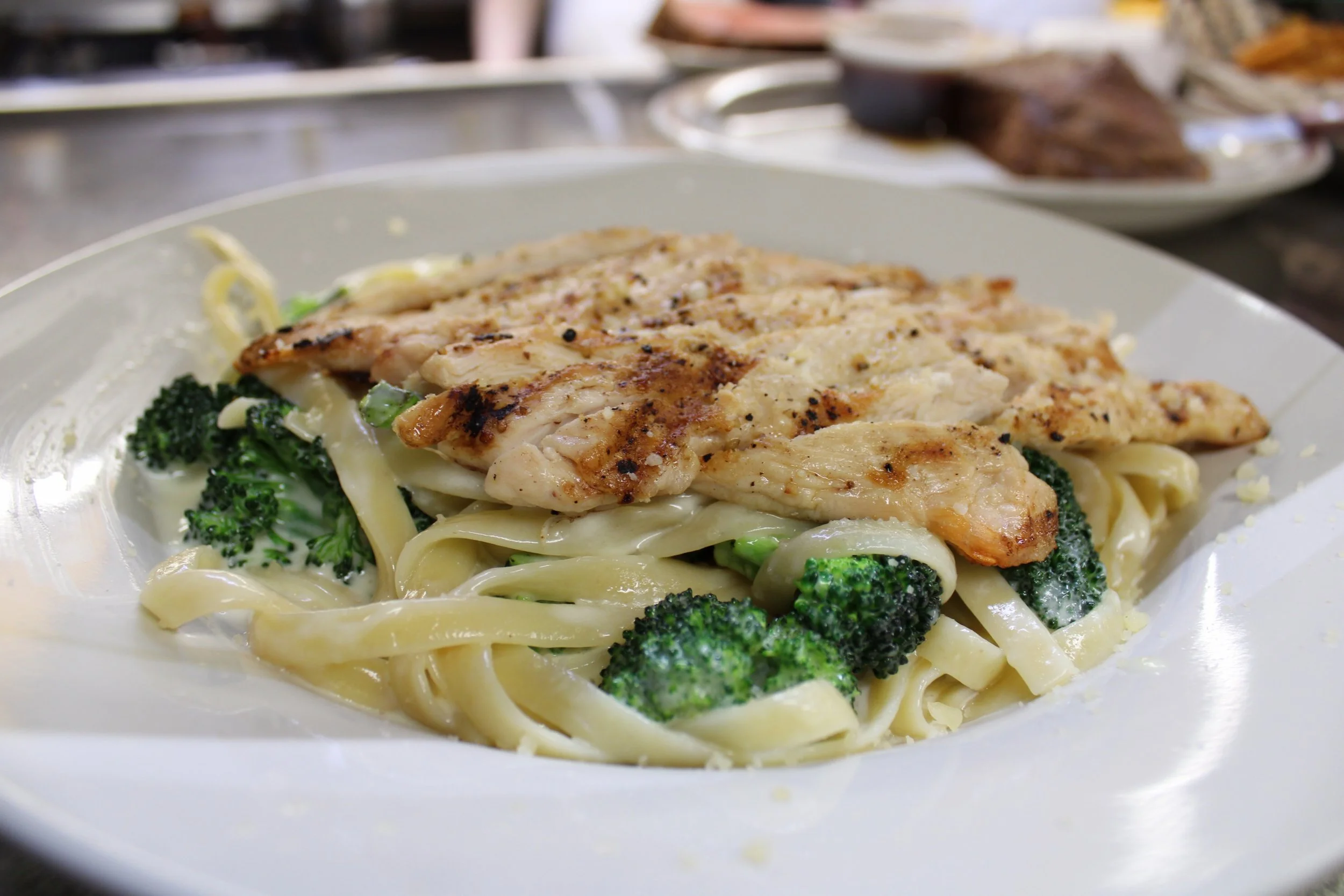 Photo of chicken and broccoli fettucini at the Sunset Cafe and Loose Wolf Saloon. The pasta dish is in a large, white bowl, sitting in the kitchen window.