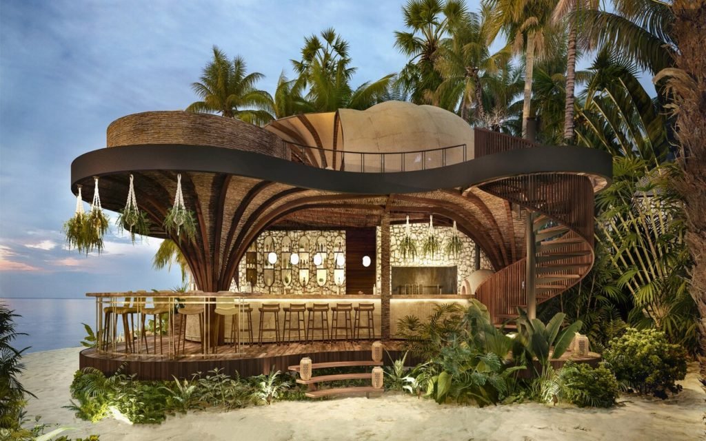 A modern, multi-level restaurant structure with curved architectural design, surrounded by tropical plants and palm trees, with an ocean view in the background.