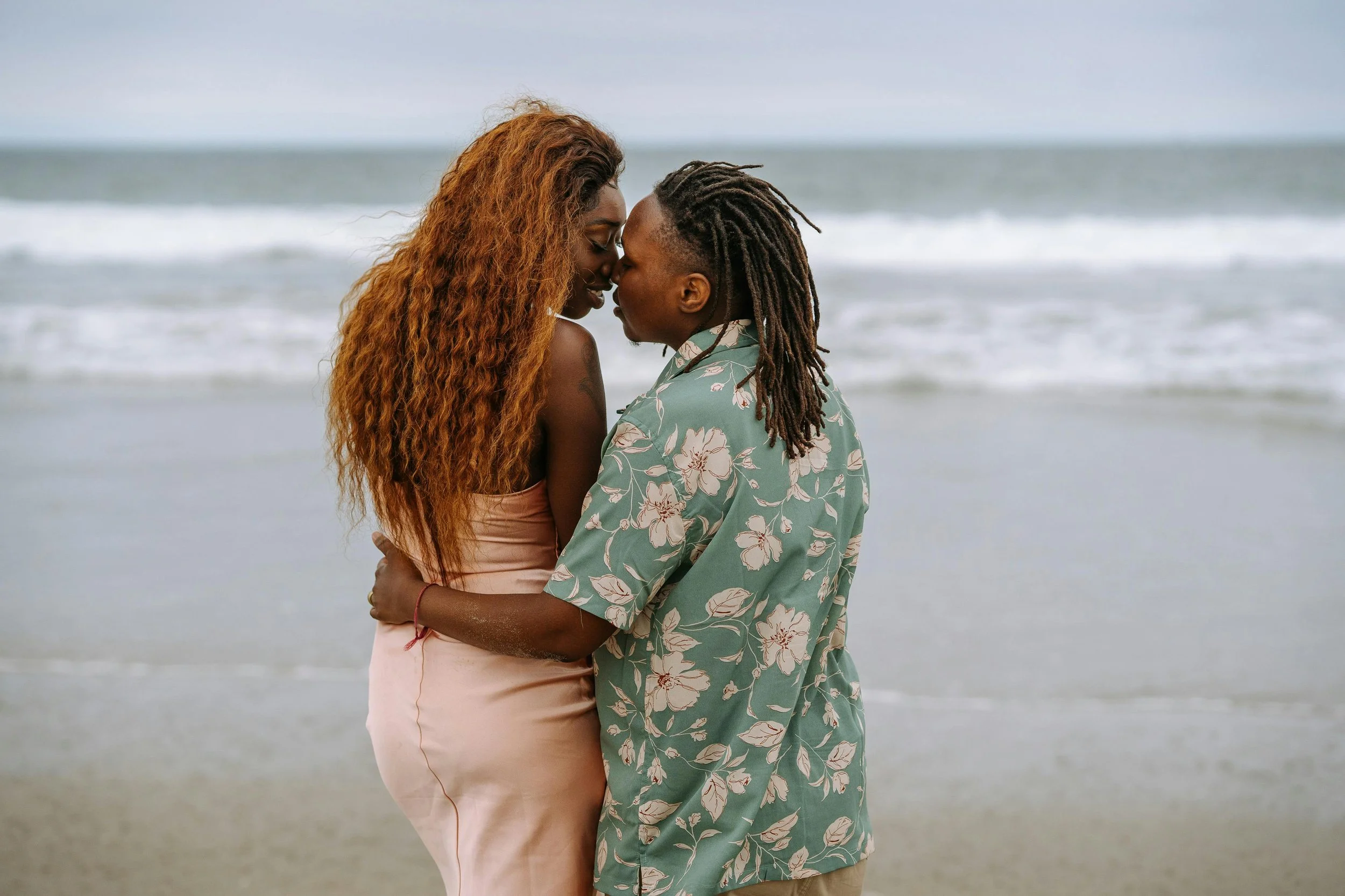 Photo of a queer black couple at the beach
