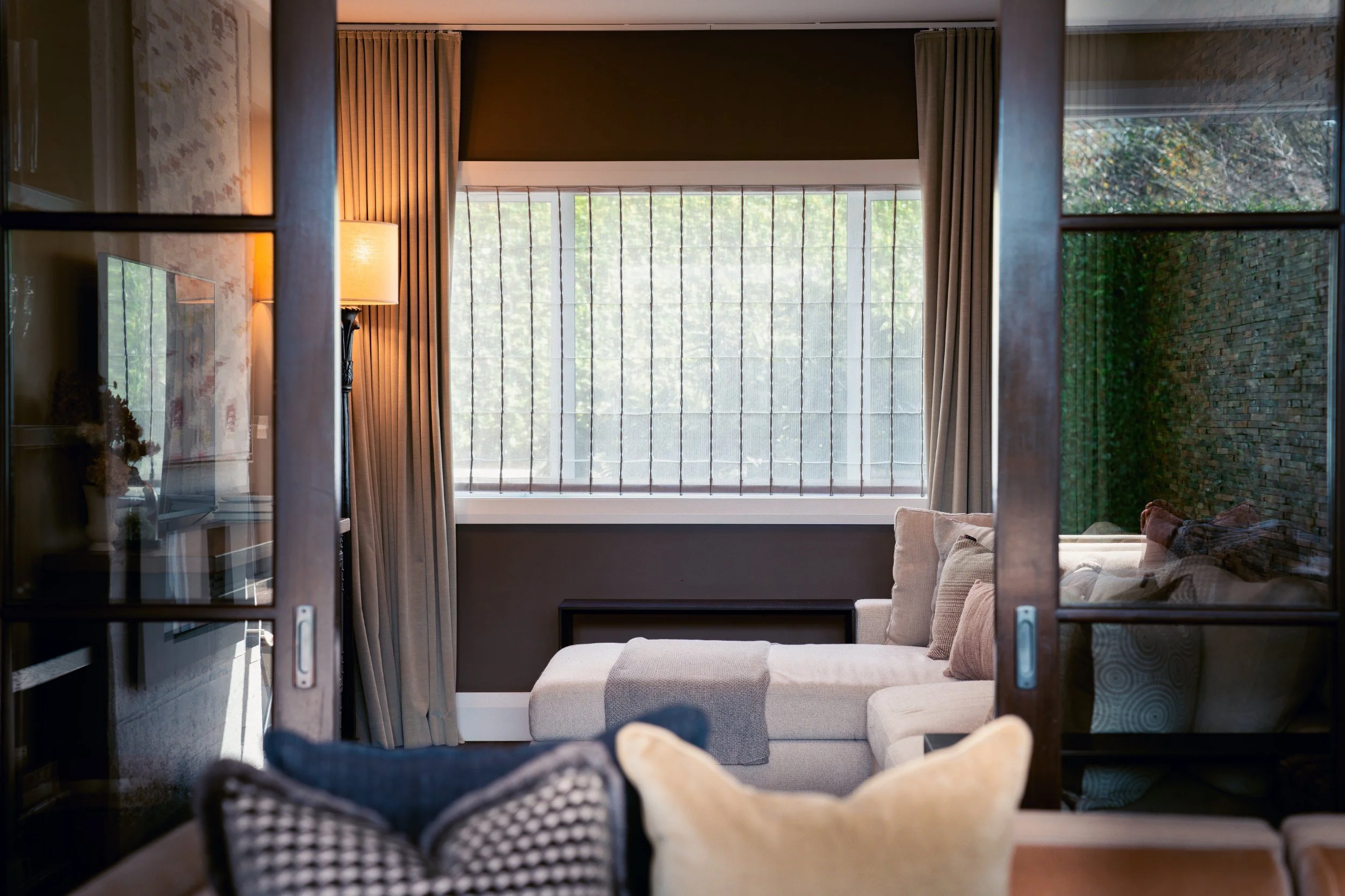 Elegant living room with full-height curtains opening to the garden, a luxury home interior by The Bridge, Auckland