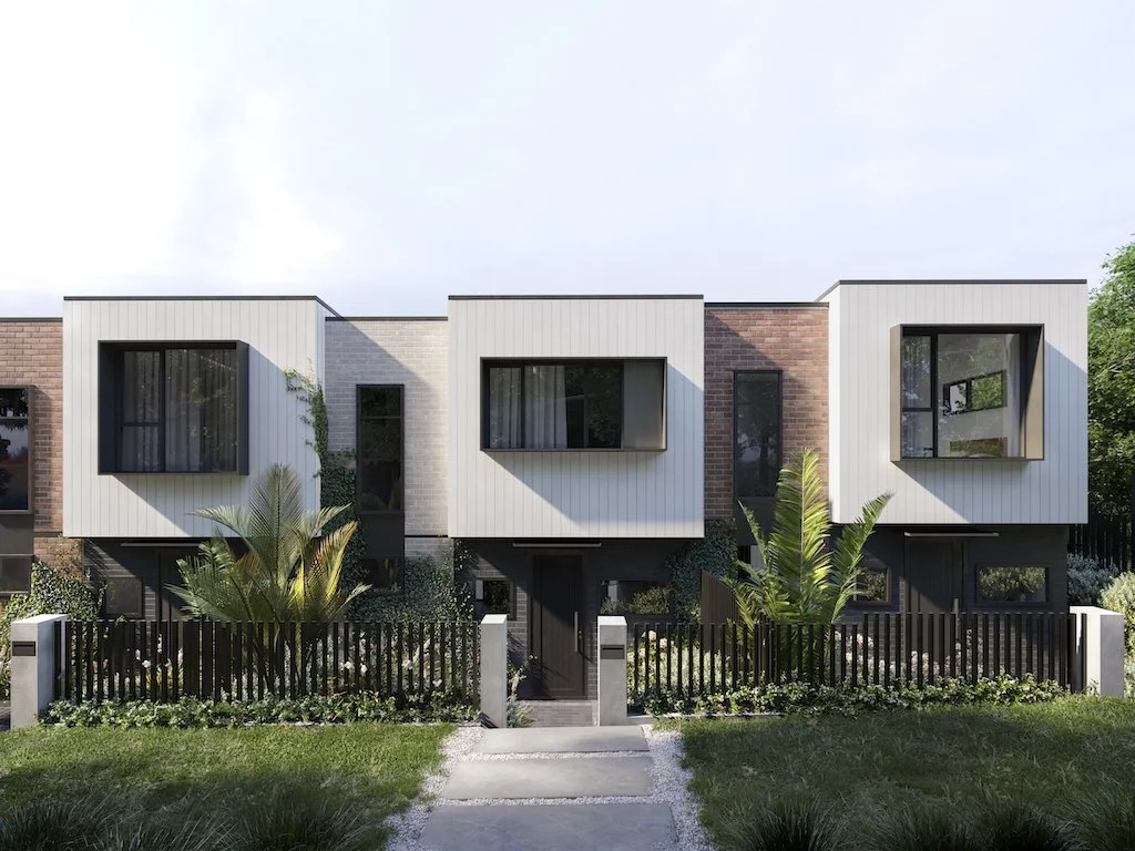 Modern multi-family residential building with distinct boxy white and brick facades and large windows, surrounded by greenery and a black picket fence.