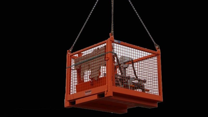 Crane Pallet Bin on crane rigging being lifted against a black back ground. The bin is orange and has clamps inside of it. These are sold be CraneGear.net in North America