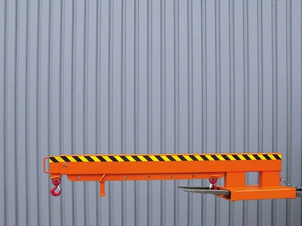 Forklift jib extension by Eichinger model 2081. The jib is on forklift forks. It is orange in color and against a gray wall as a background.