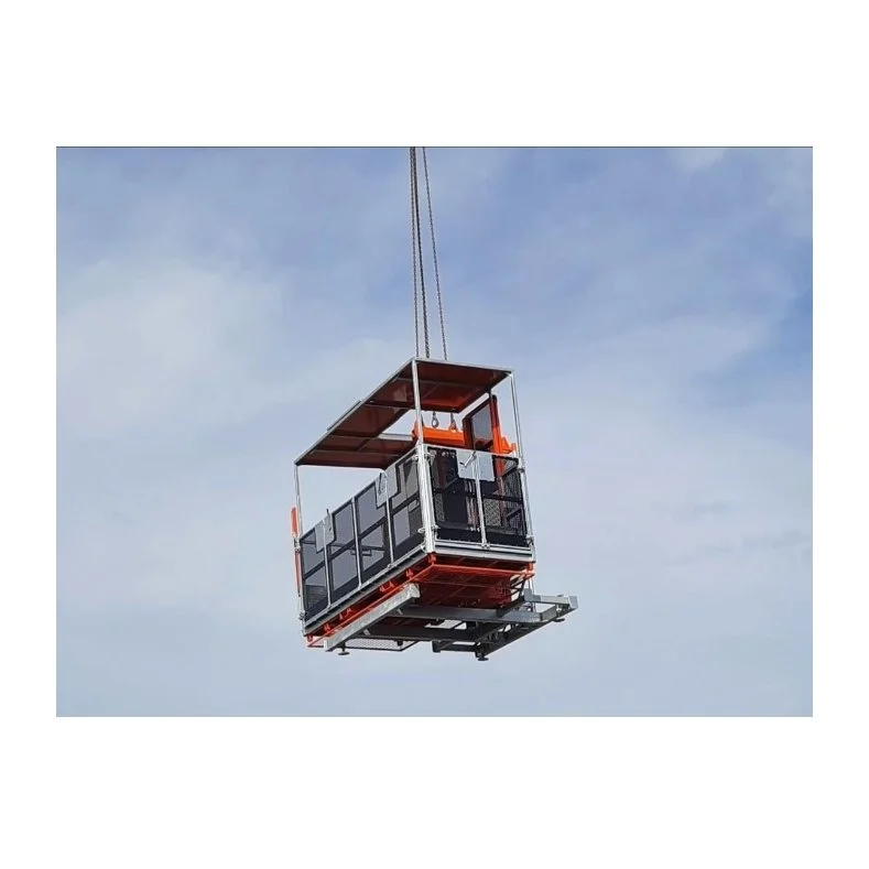 materials handling hoist being lifted into position with a crane. The background is the sky with some light clouds.