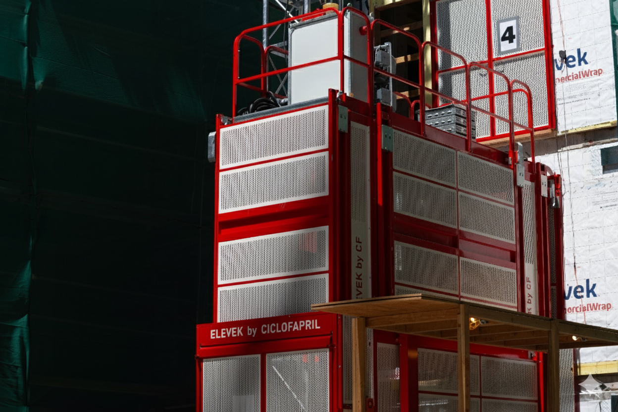 Construction personnel Hoist on a builign project ready to safely hoist workers. This equipment is red and white on a black and white job site.