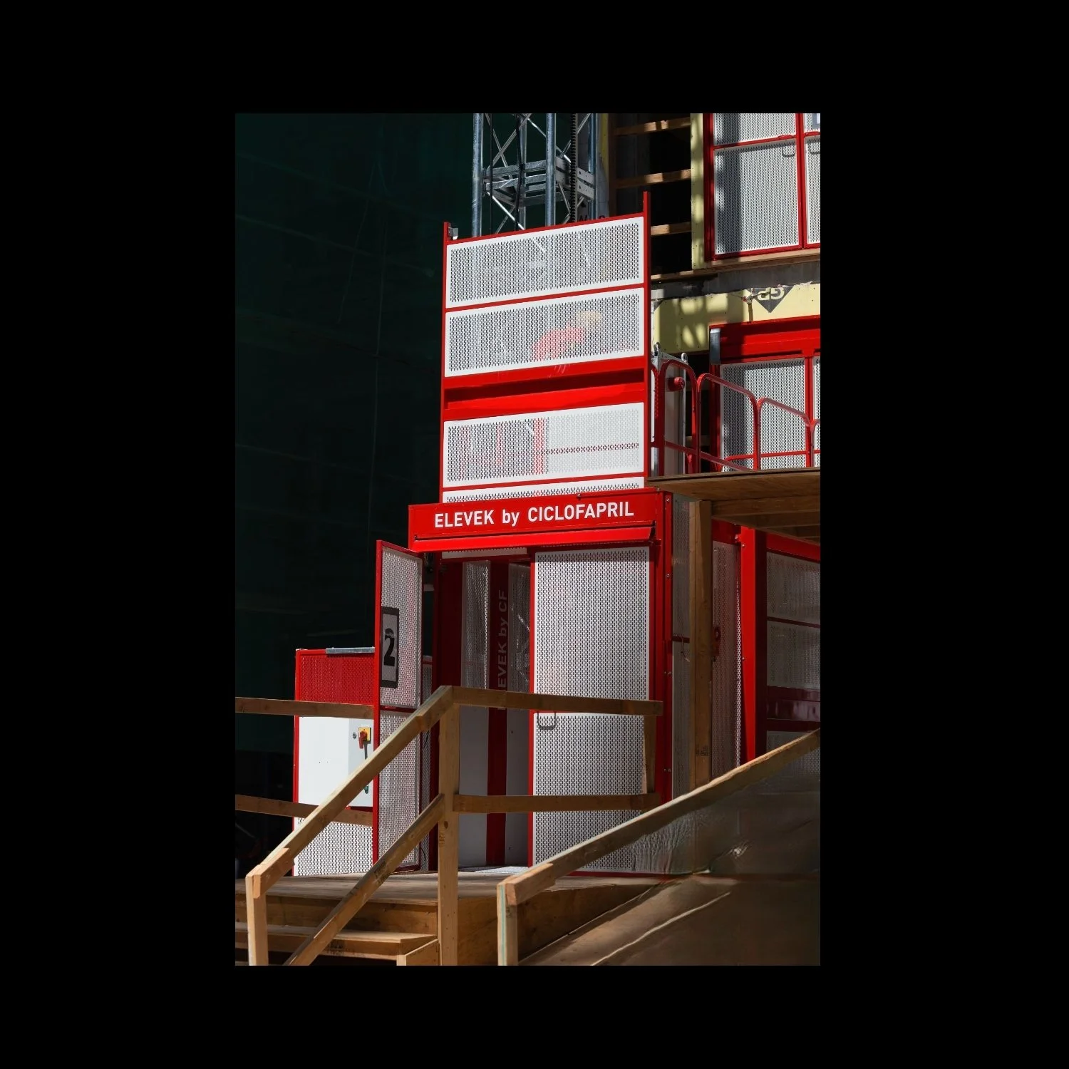 Construction hoist used to safely move worked with efficiency. Red and white enclosure.