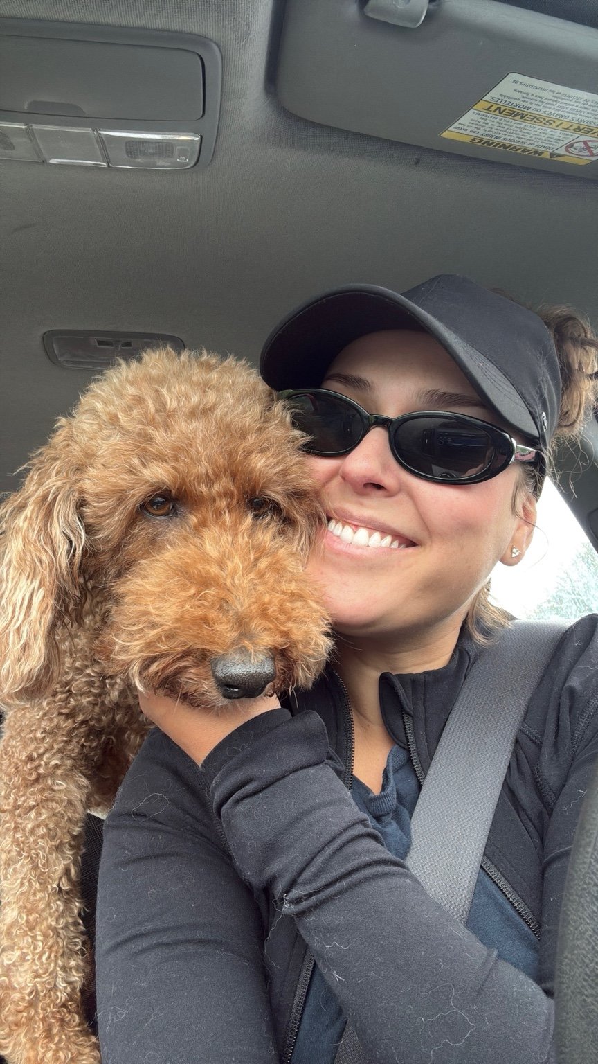 Melissa from Zoomies Adventures in Ottawa. Posing with a Golden Doodle dog named Winnie
