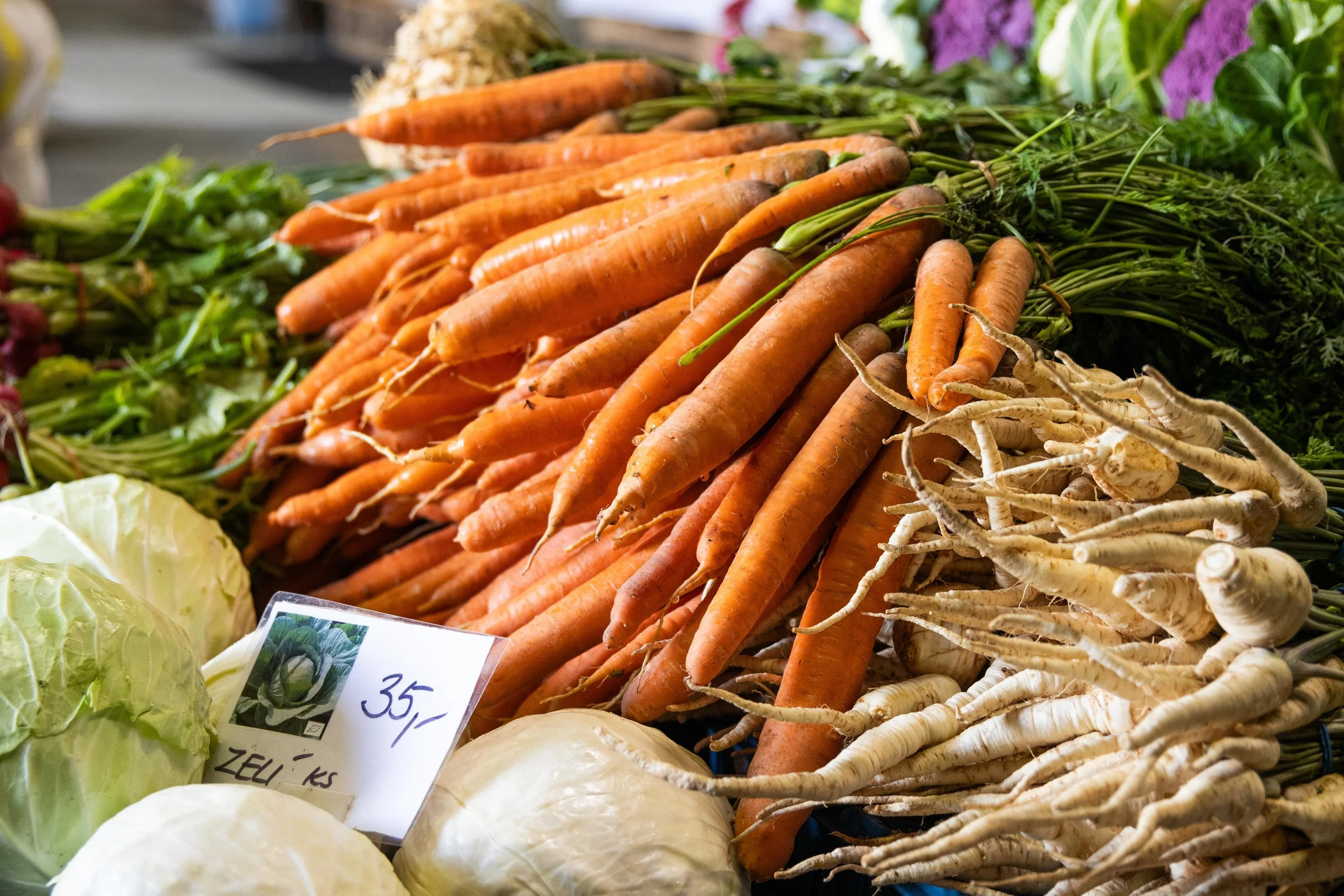 Fresh carrots and parsnips on display at a produce market