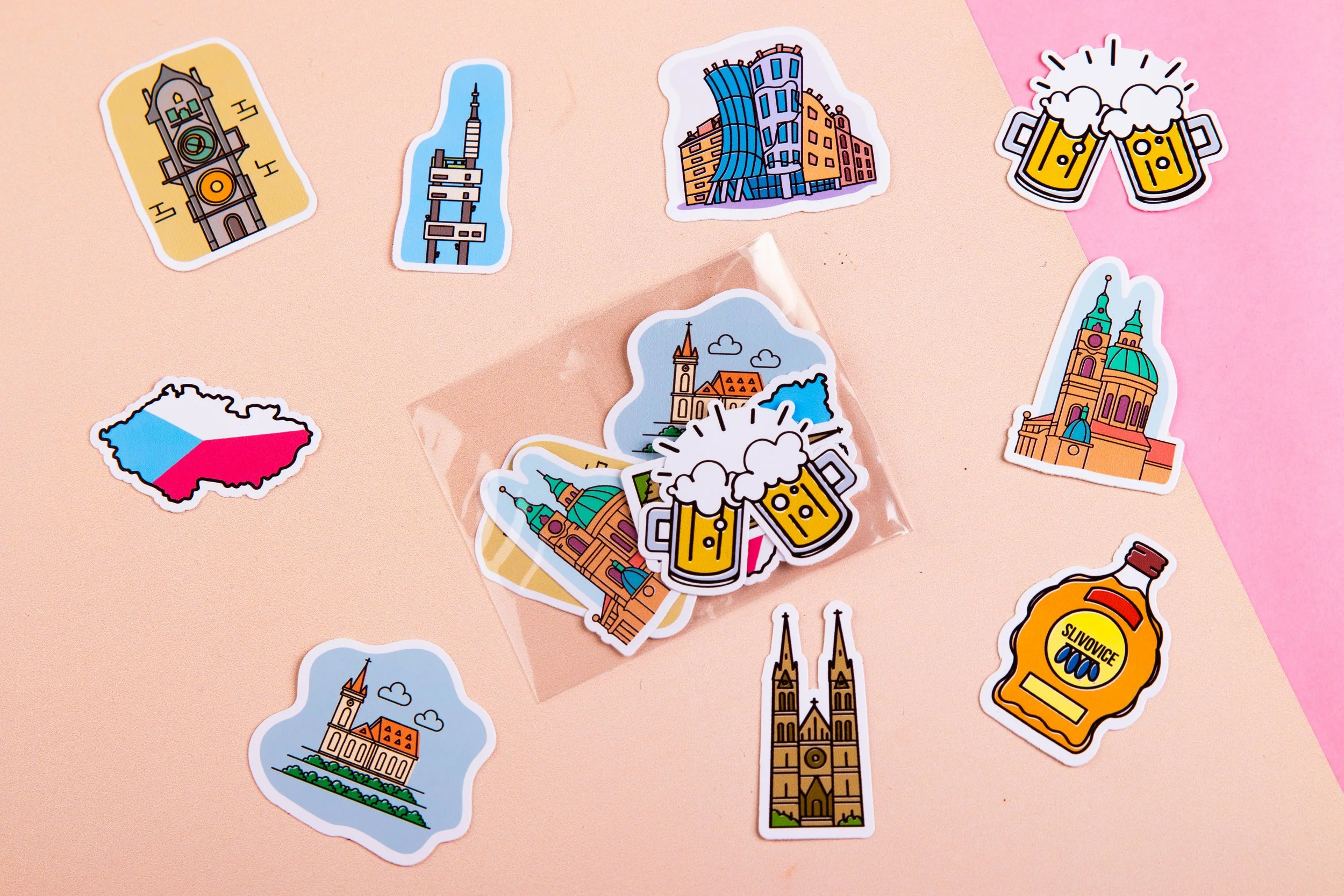 Collection of colorful stickers featuring European landmarks, beer mugs, a bottle, and a map of Czechia on a pastel pink and beige background.