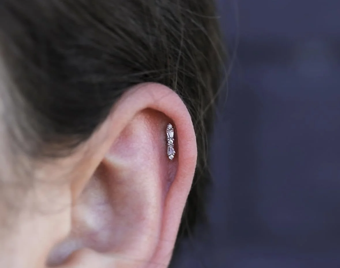 Baguette cut and round cut stones set in solid 14k white gold for this cartilage piercing done by @darby.pokes