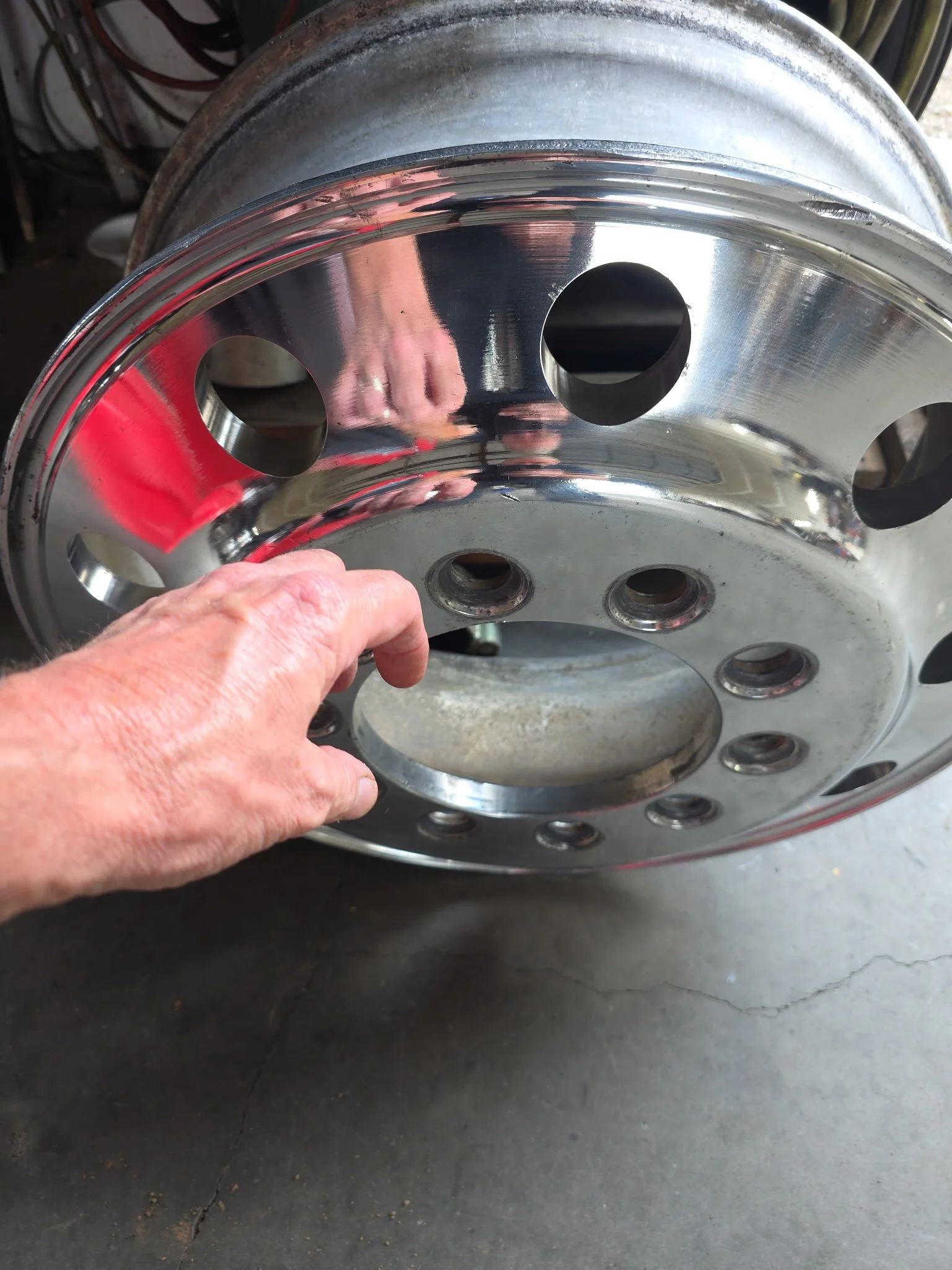 Aluminum wheel reflecting a hand