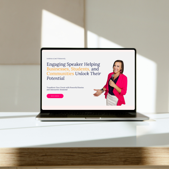 Laptop on a white table displaying a presentation slide with a woman in a pink blazer holding a microphone, promoting engaging speakers for businesses, students, and communities.