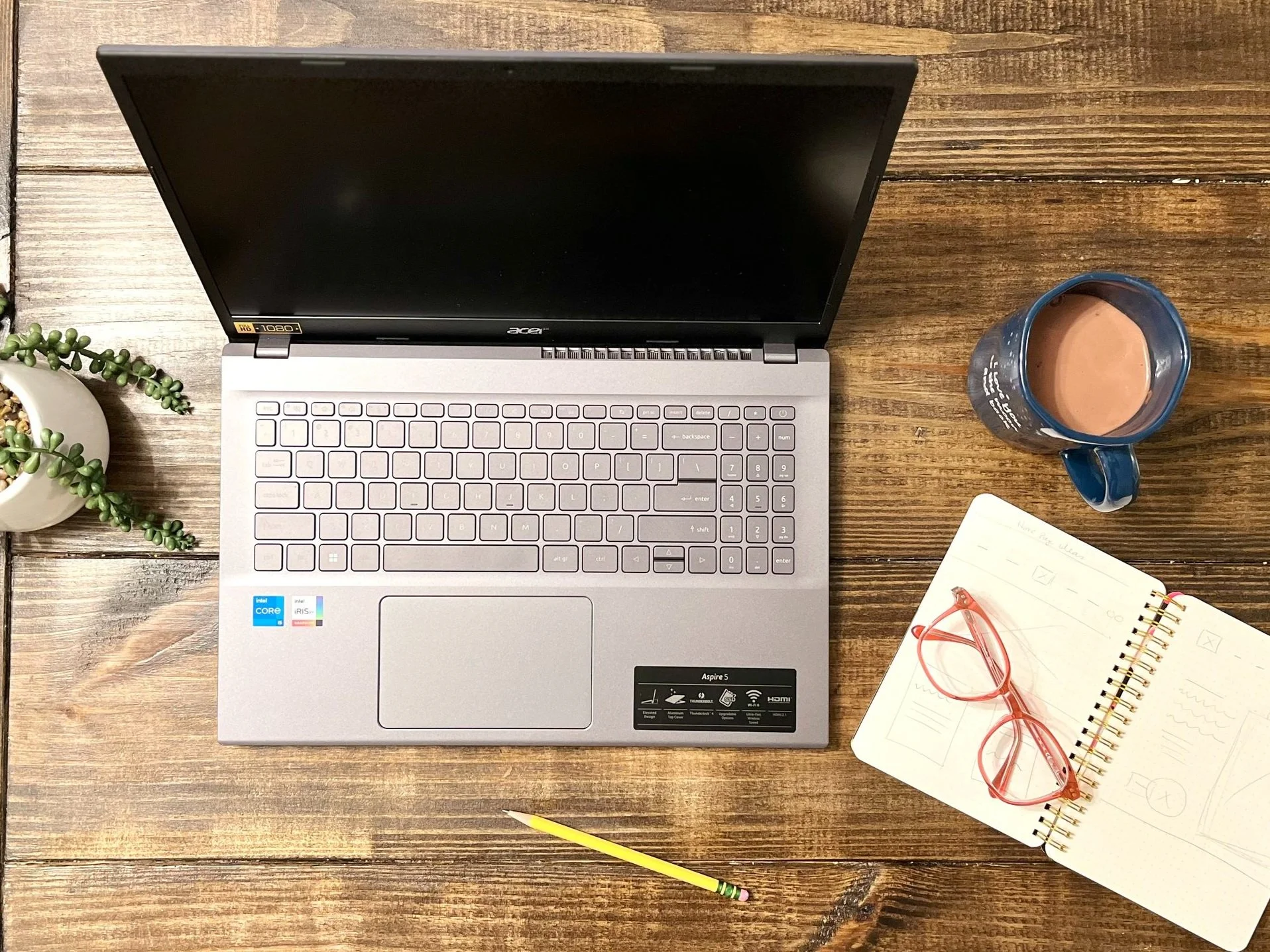 laptop with notebook of web design sketches