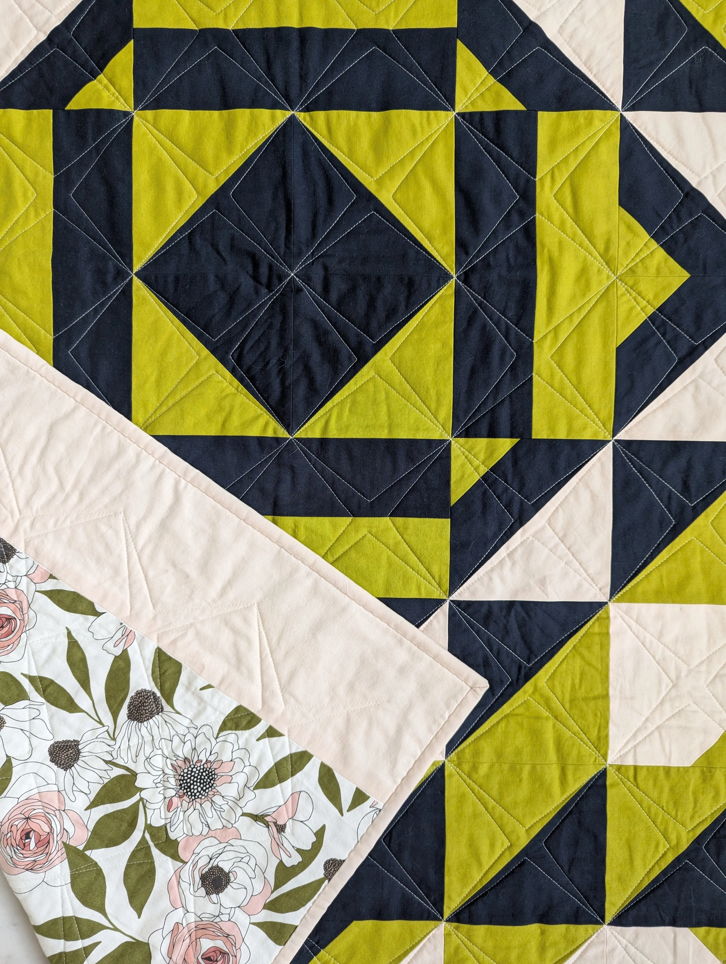 Close up of The 279 Quilt by Millie & Bun Designs in blue, green, and pink colors