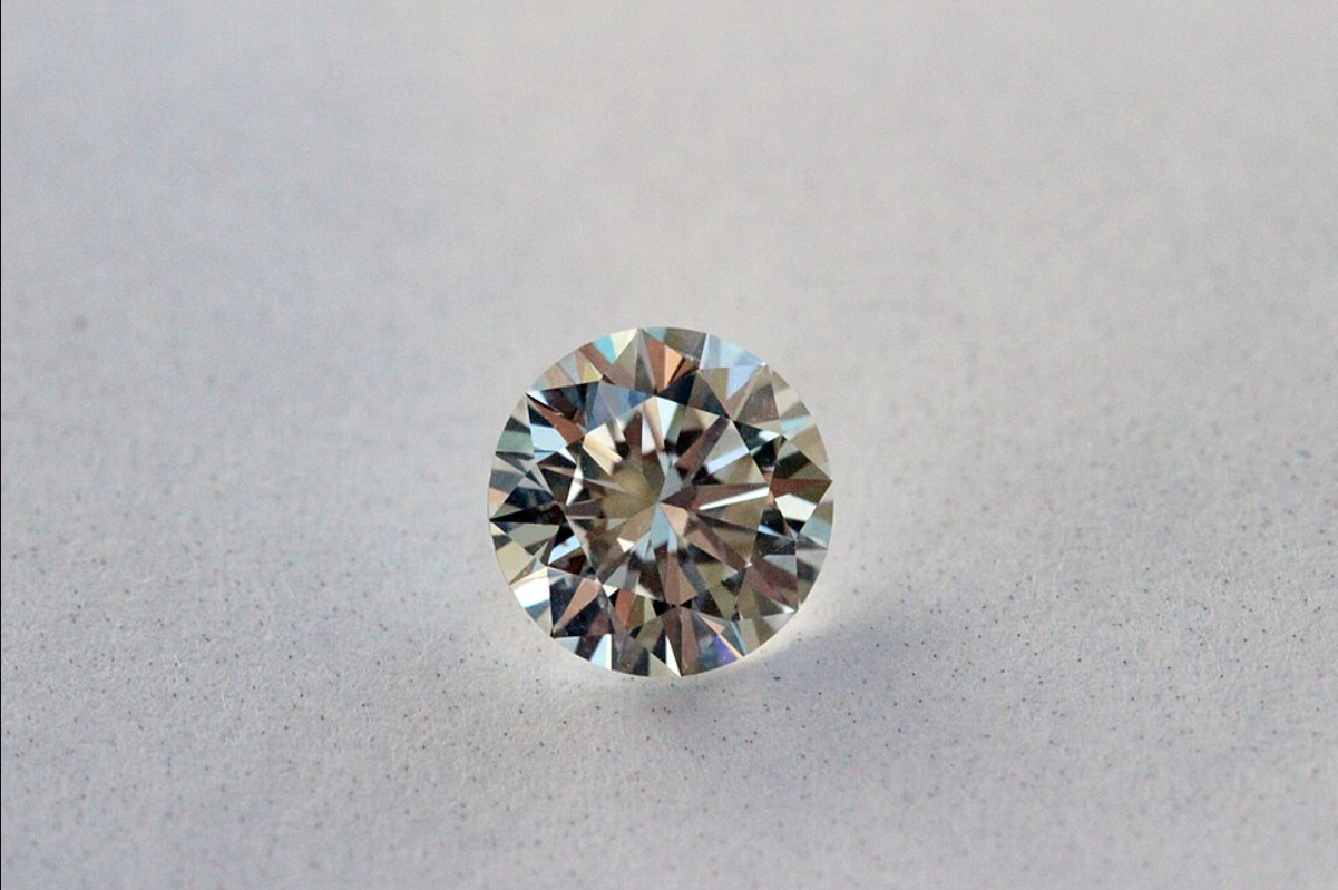 Diamant taille brillant rond, pierre seule sur fond neutre, illustrant les critères des 4C (carat, couleur, clarté, taille)