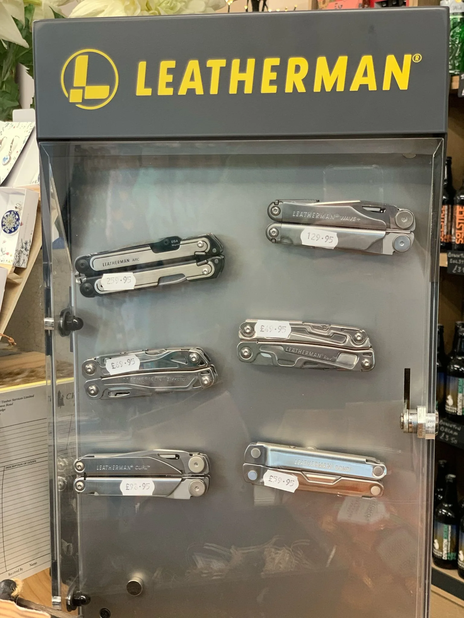 Display case with various Leatherman multi-tools on shelves, each labeled with a price tag, under the Leatherman logo.