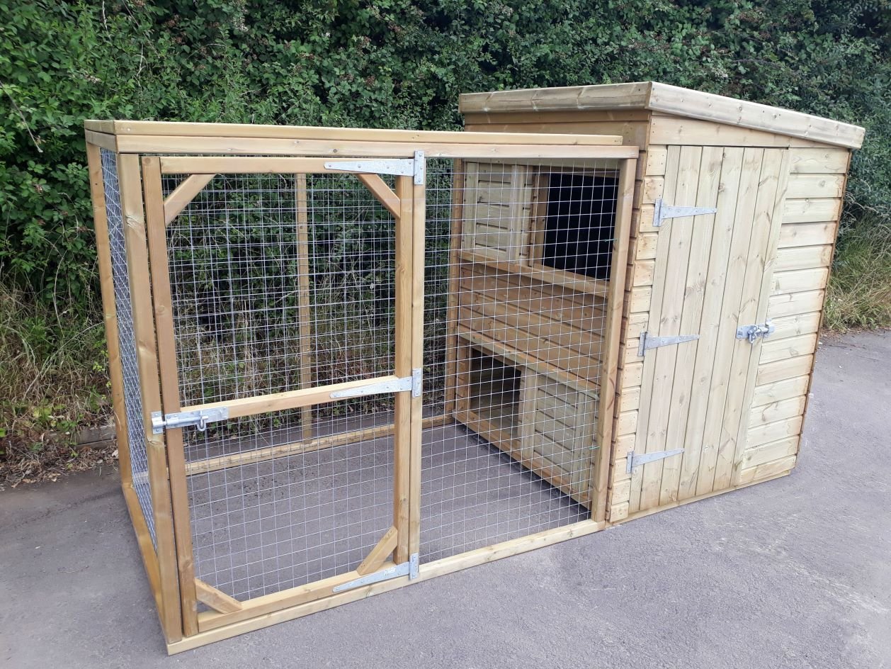 Wooden pet enclosure with wire mesh, suitable for outdoor use, on a paved area surrounded by greenery.