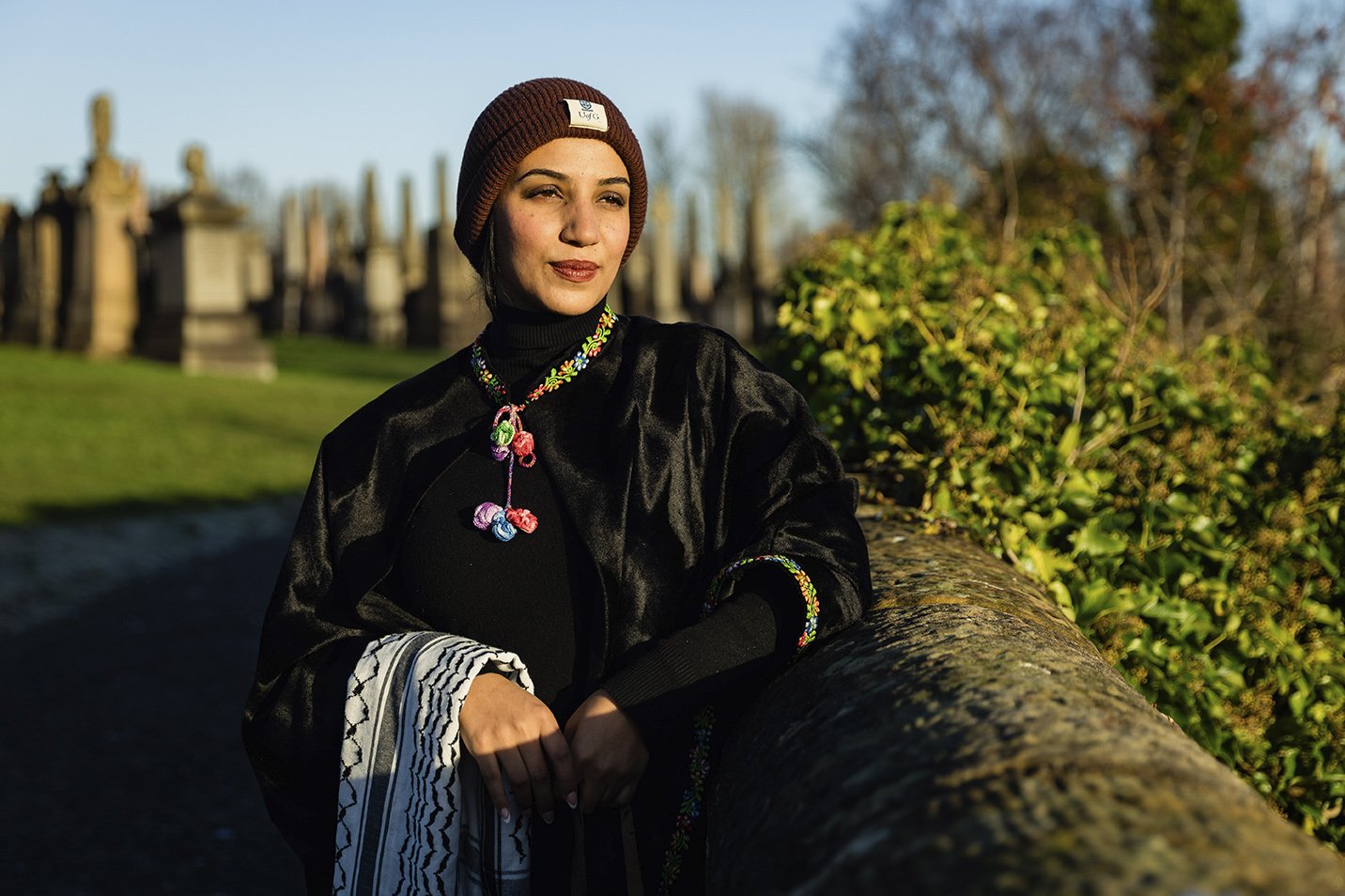 A woman outdoors during late afternoon sunlight, wearing a maroon knit hat. Image shot by Portrait photographer Mark Gillies, based in Glasgow. Image features Farida AlGhoul of Palestine. 