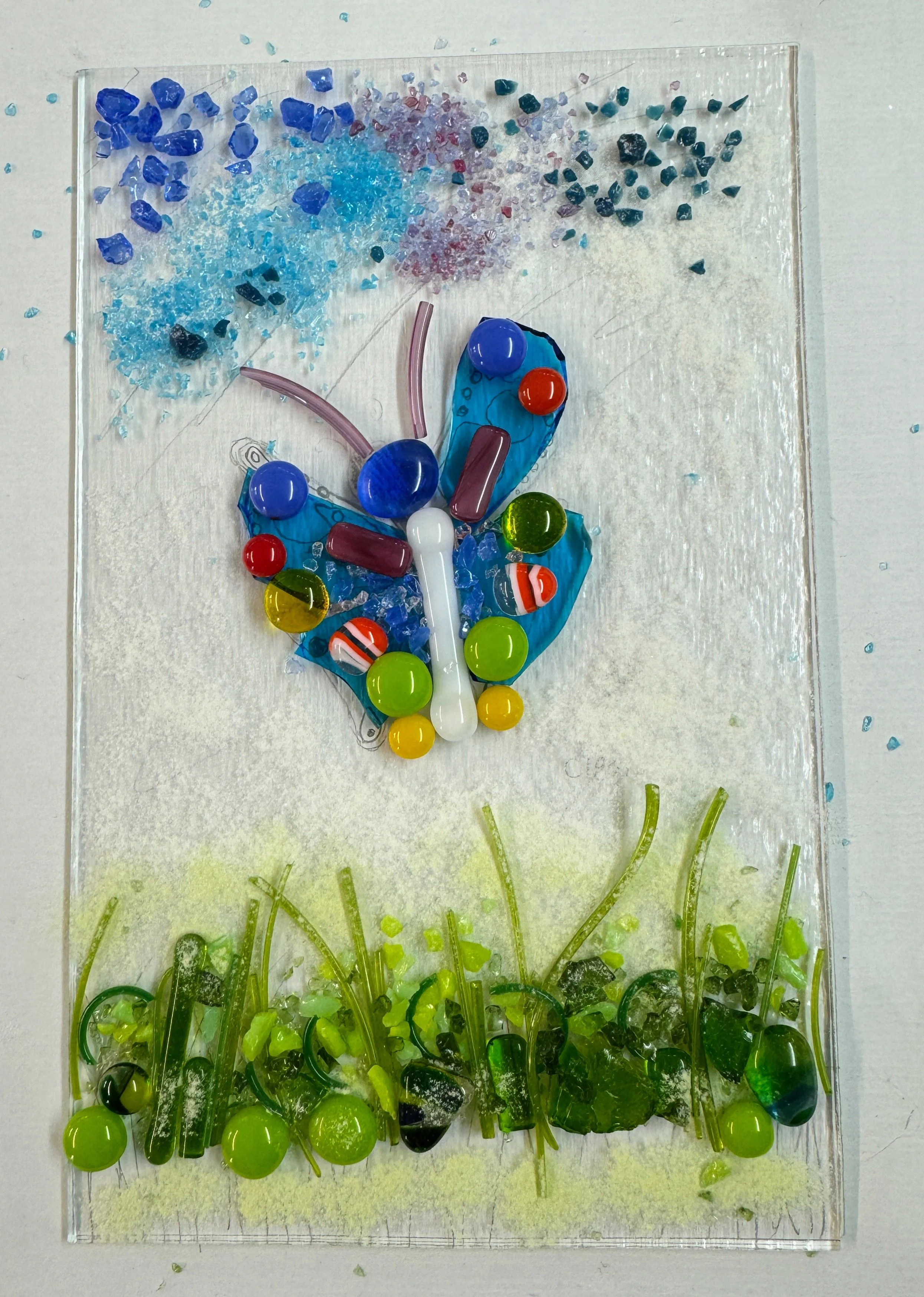Colorful glass mosaic art with butterfly and grass design