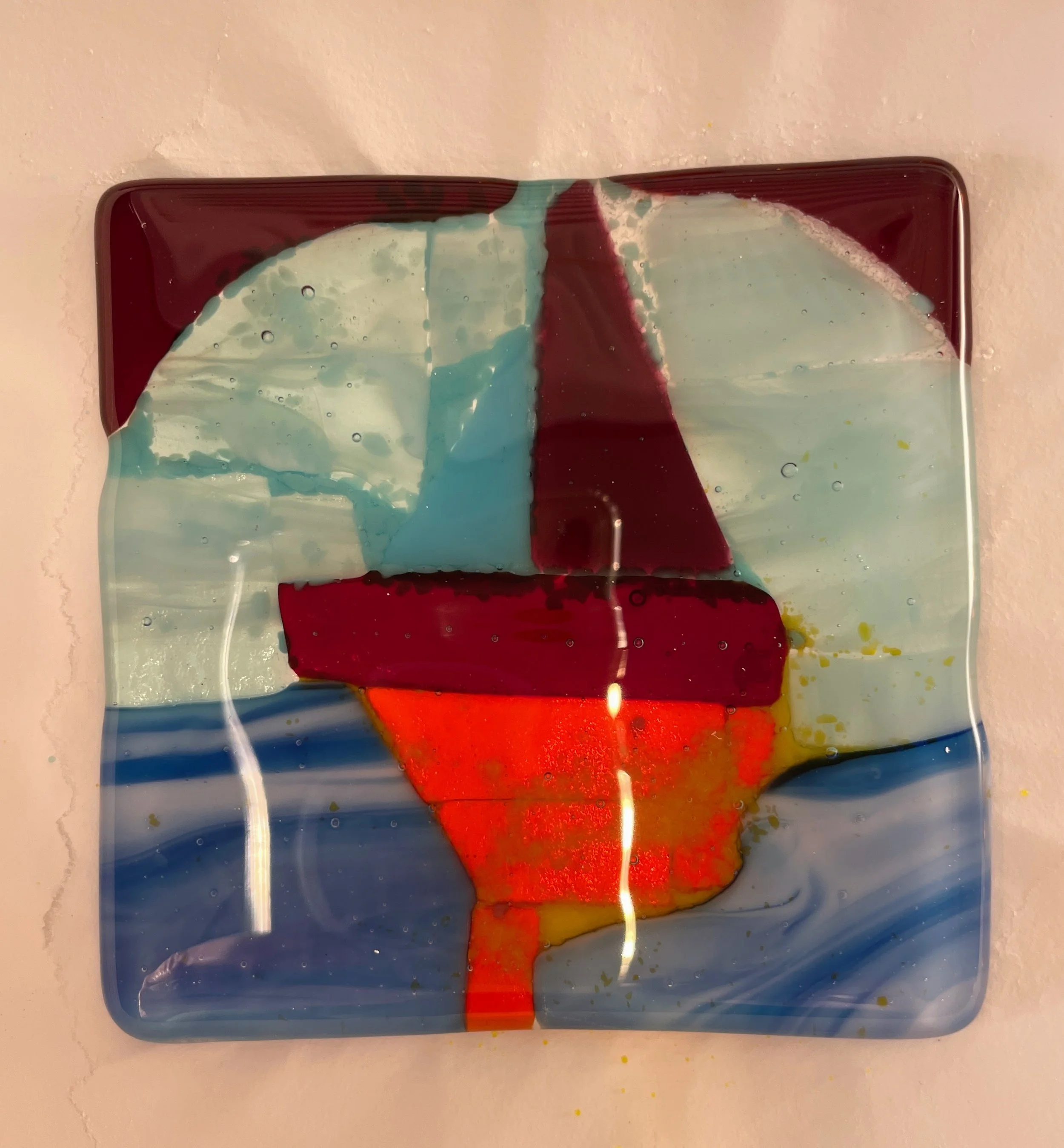 Colorful glass art depicting a sailboat on water