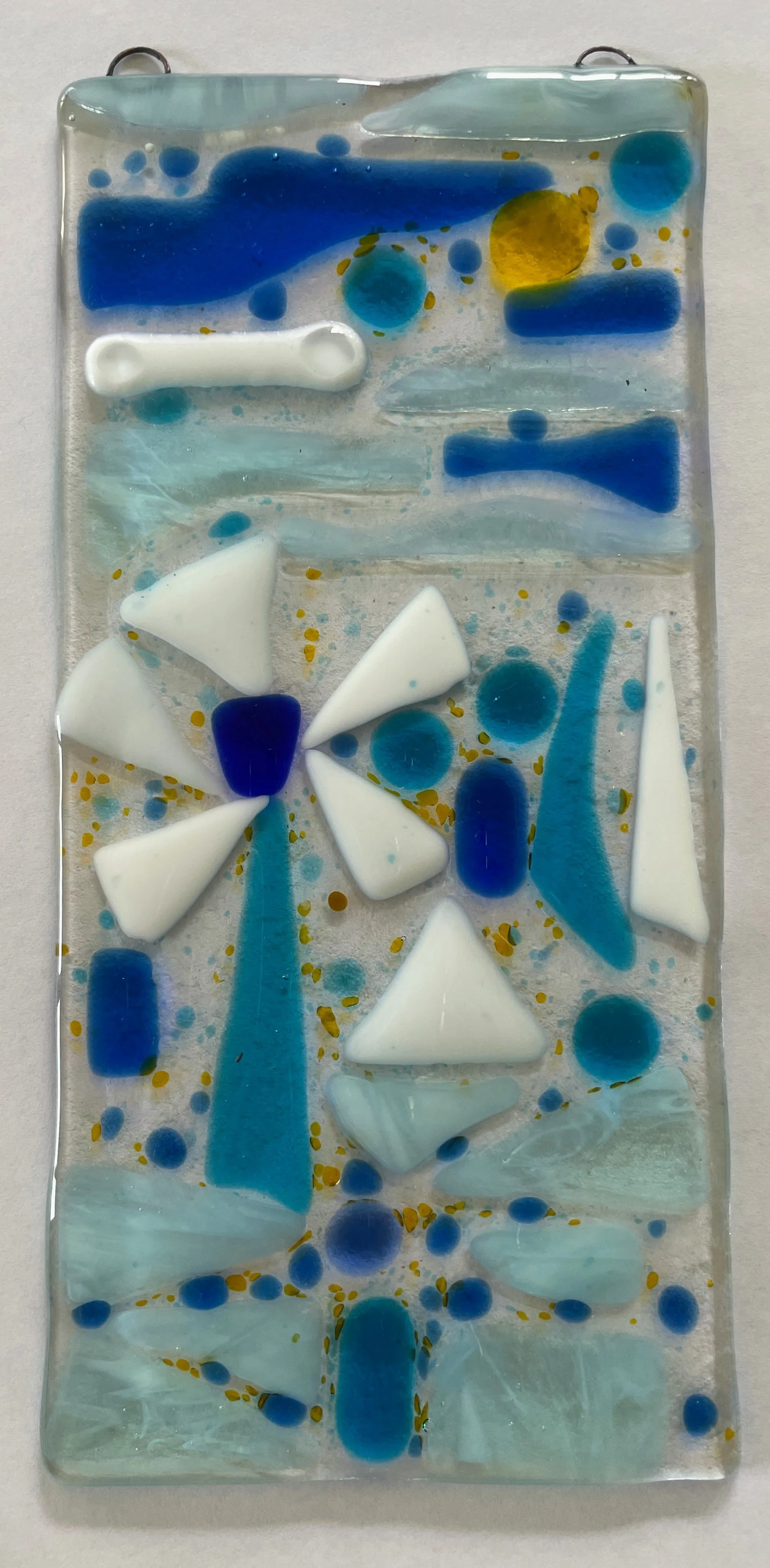 Decorative glass art piece with abstract design in blue, white, and yellow