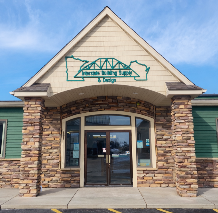 Front of a building with a sign that reads 'Interstate Building Supply & Design' featuring an outline of Texas and a bridge structure.