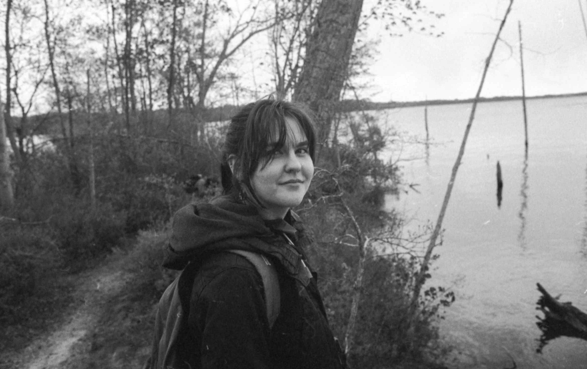 A picture of Megan on a hike by a lake.