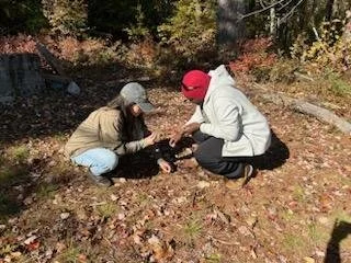 Ray shows Sulwan how to identify winterberries during a visit to Land in Common in Greene, ME.
