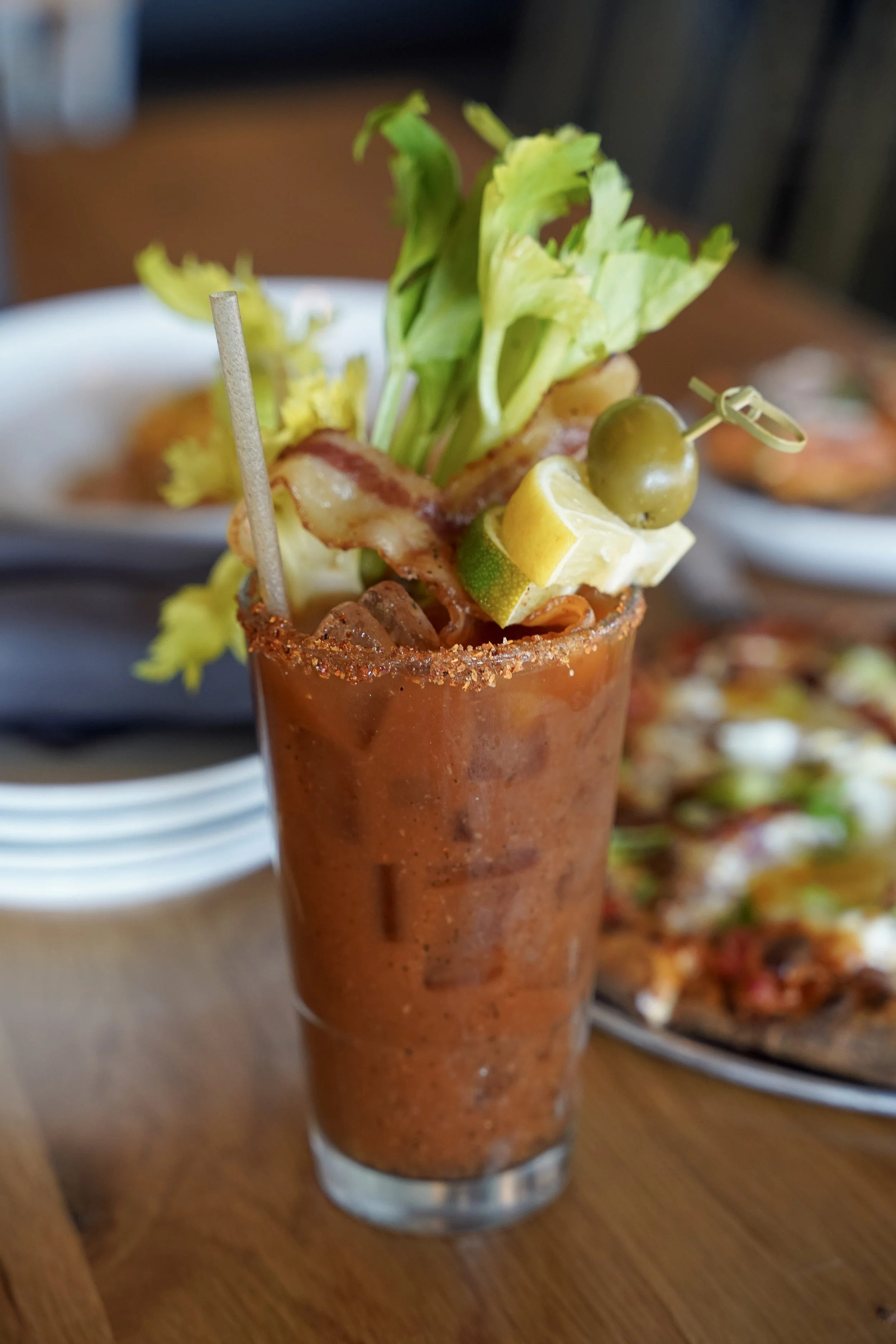 Garnished Bloody Mary with celery, bacon, olive, and lemon served during brunch at Liberty Tavern in Polaris, Ohio.