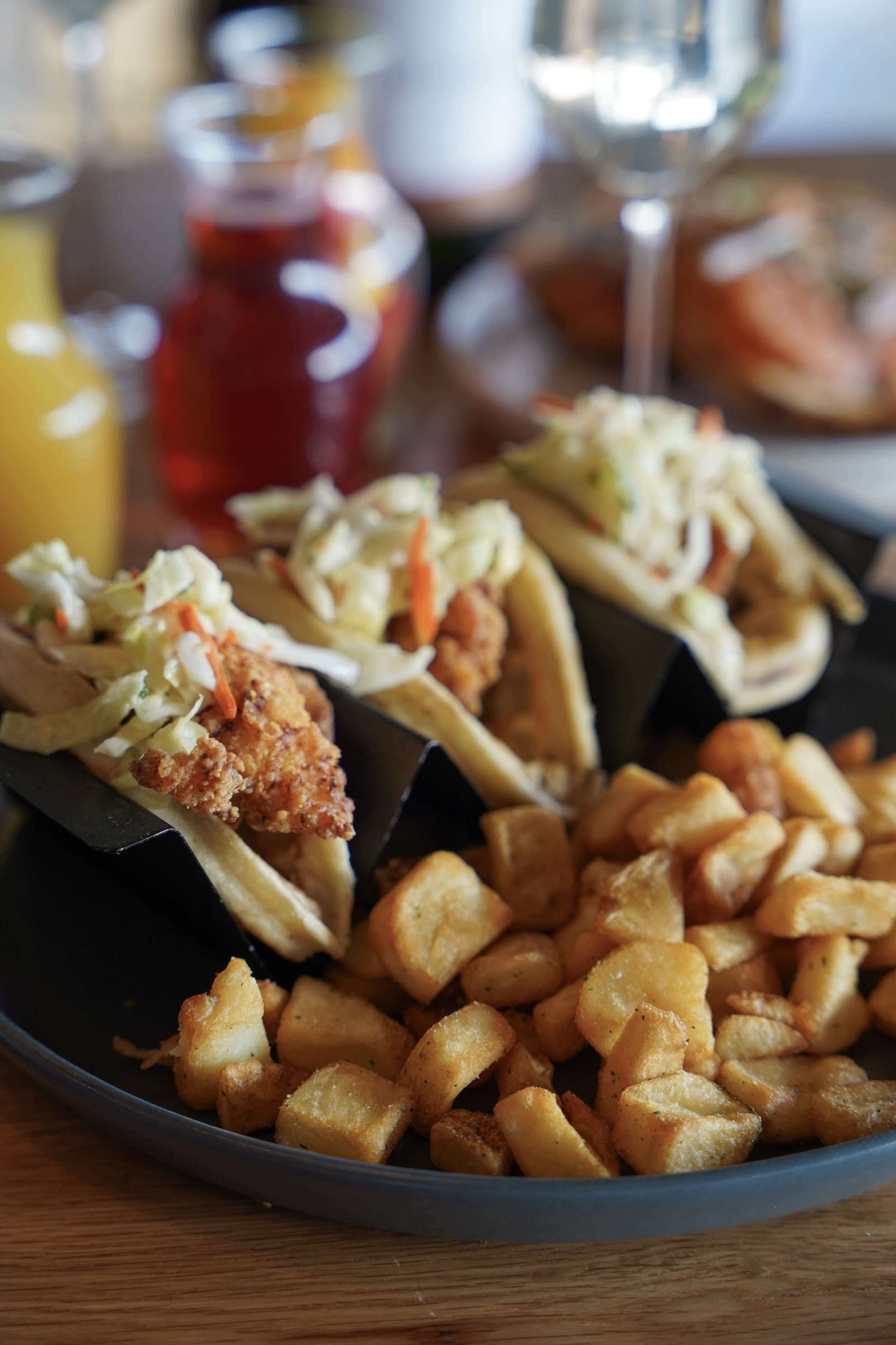 Crispy chicken brunch tacos topped with slaw and served with roasted breakfast potatoes at Liberty Tavern in Polaris, Ohio.