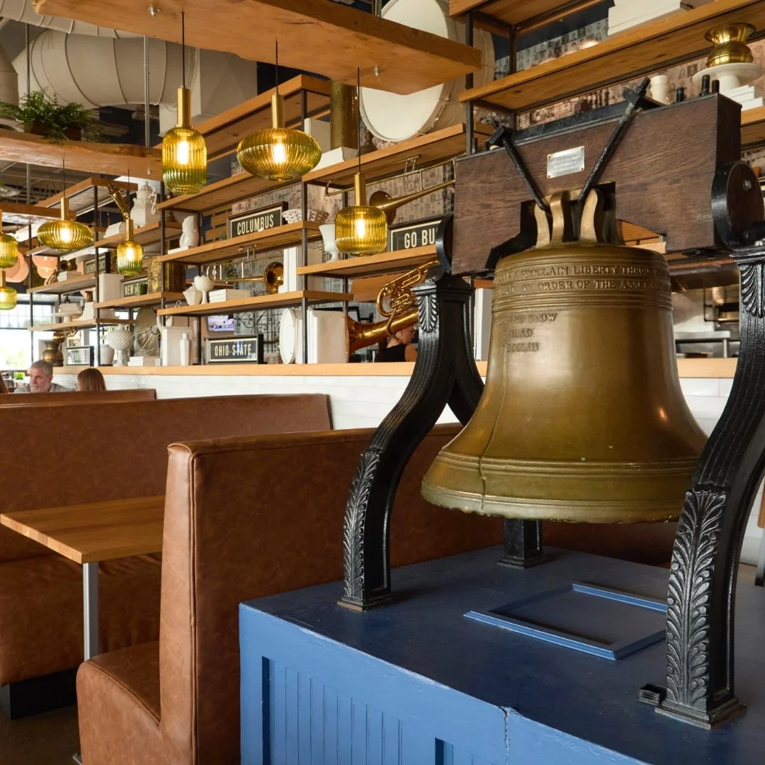 Private dining booths and Liberty Bell centerpiece inside Liberty Tavern Polaris, a stylish Columbus event venue for group gatherings and celebrations.