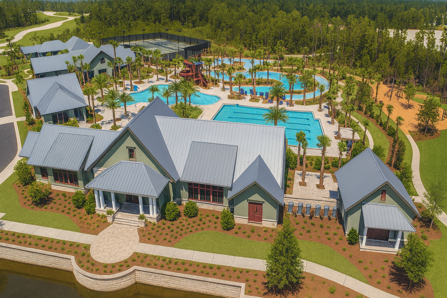 Aerial view of a resort-style water park with pools, water slides, and surrounding buildings, landscaped with palm trees and walking paths.