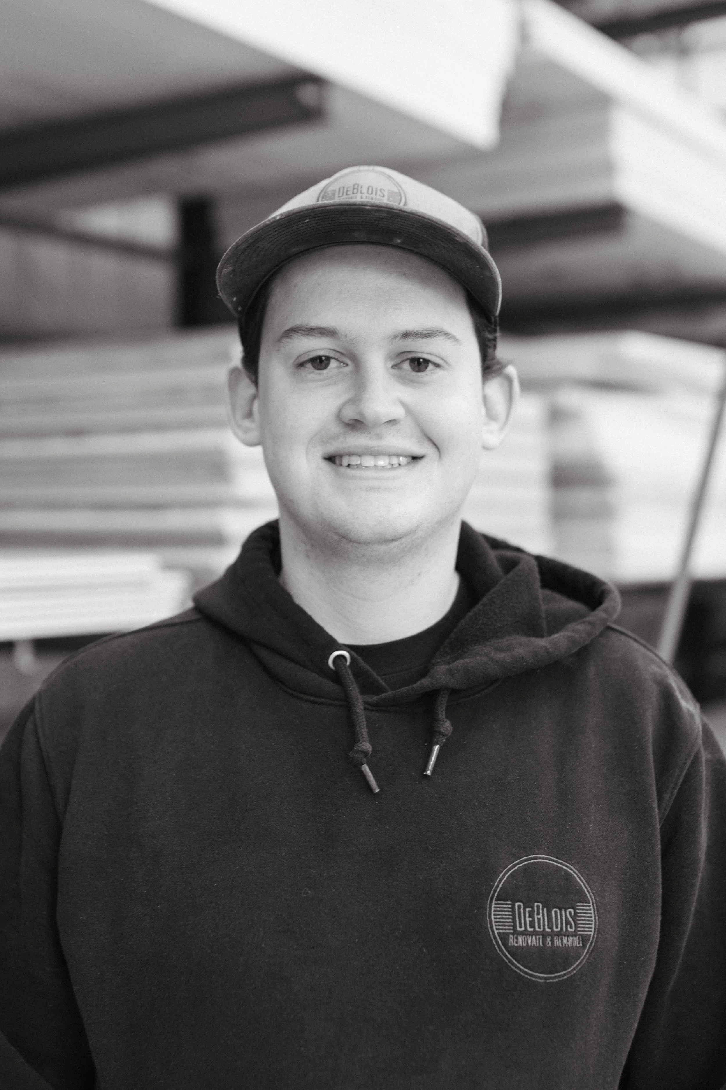 Alex Farley, painter, pictured smiling outside wearing a blue hoodie