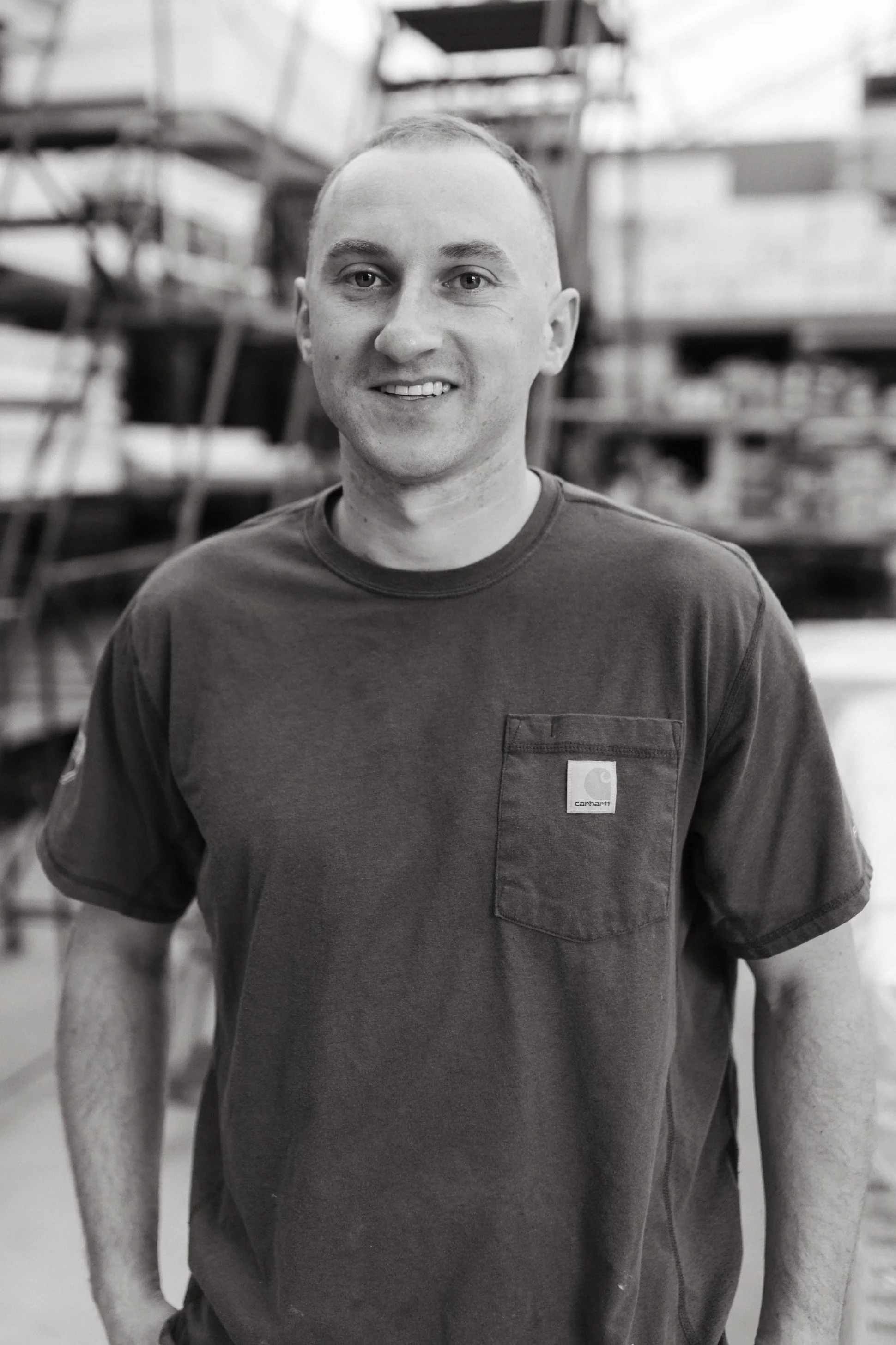 Aaron Malay, carpenter, pictured smiling outside wearing a t-shirt